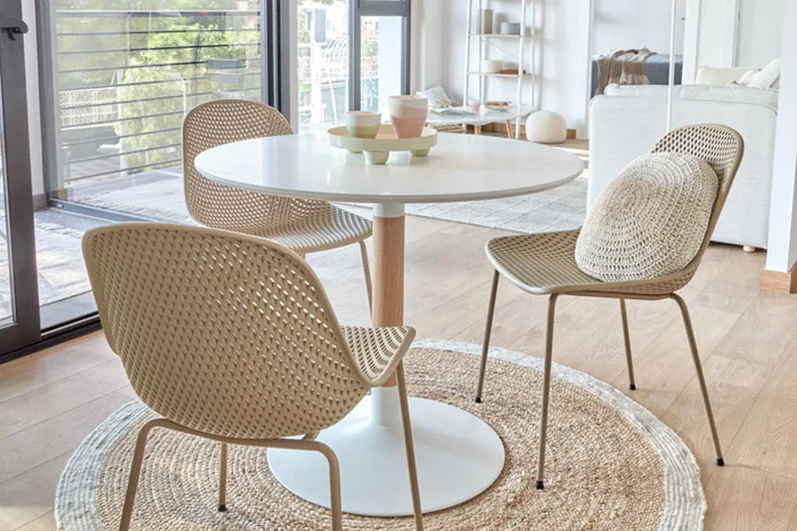 Outdoor Stuhl Quinby von Kave Home in Beige mit ergonomischer Sitzfläche aus Kunststoff und stabilem Stahlgestell, auf einer Terrasse platziert.