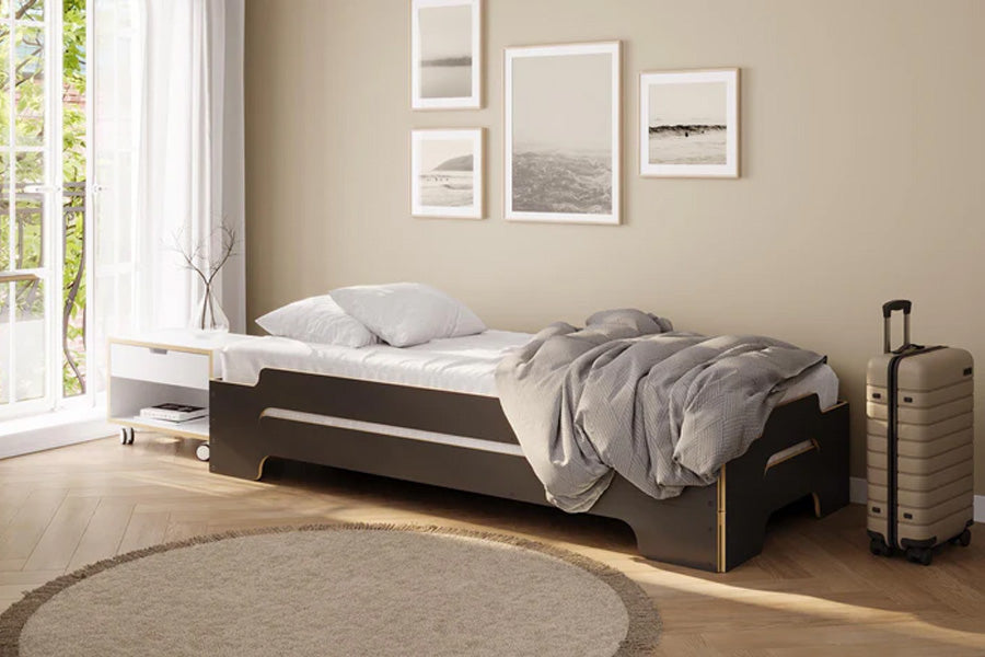 Stapelliege von Müller, stapelbares Bettgestell aus robustem Metall mit dünner Matratze, platzsparendes Design für Gästezimmer oder Gemeinschaftsräume.