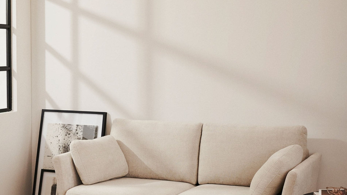 Gilma 3-Sitzer-Sofa von Kave Home mit Chaiselongue in grüner Chenille und schwarzen Beinen in einem hellen Wohnraum