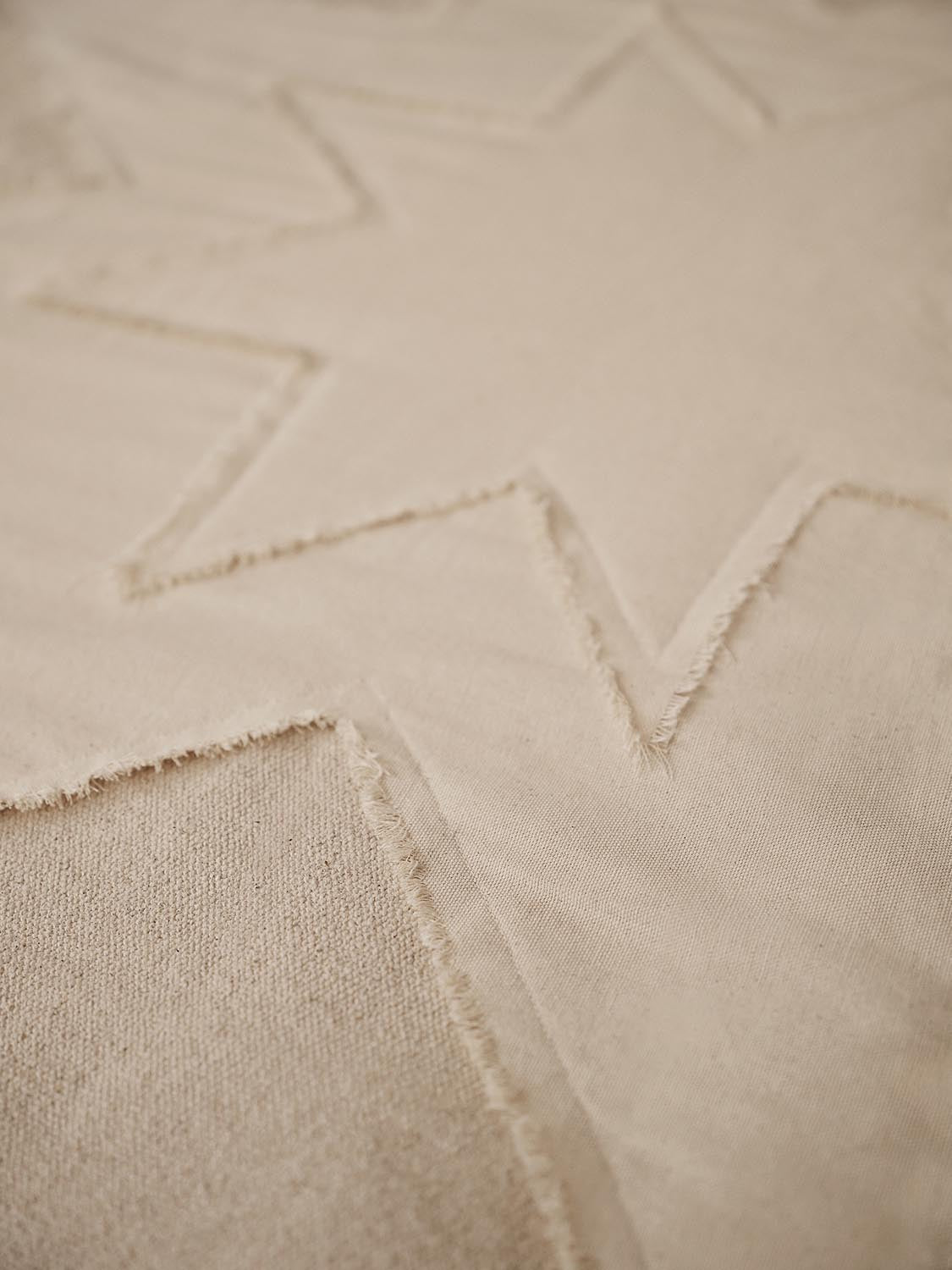 Erlebe die Vela Star Weihnachtsbaumdecke von Ferm Living – ein stilvolles, handgefertigtes Accessoire aus nachhaltiger Bio-Baumwolle, das festliche Eleganz bringt.