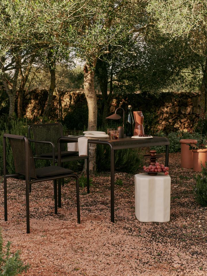 Erlebe den Dapple Stuhl mit Armlehnen von Ferm Living – eine harmonische Verbindung aus modernem Design und robustem Komfort für deinen Außenbereich.