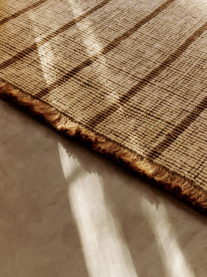 Entdecken Sie den Athen Stripes Teppich 200 x 300 von Ferm Living – handgewebt aus Jute, mit zeitlosem Streifendesign und rustikalen Fransen.