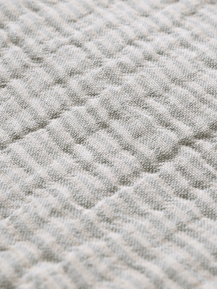 Verleihen Sie Ihrem Schlafzimmer mit dem Fino Bettüberwurf von Ferm Living einen Hauch von Eleganz und Komfort. Hergestellt aus nachhaltiger Baumwolle, bietet er Wärme und Stil.