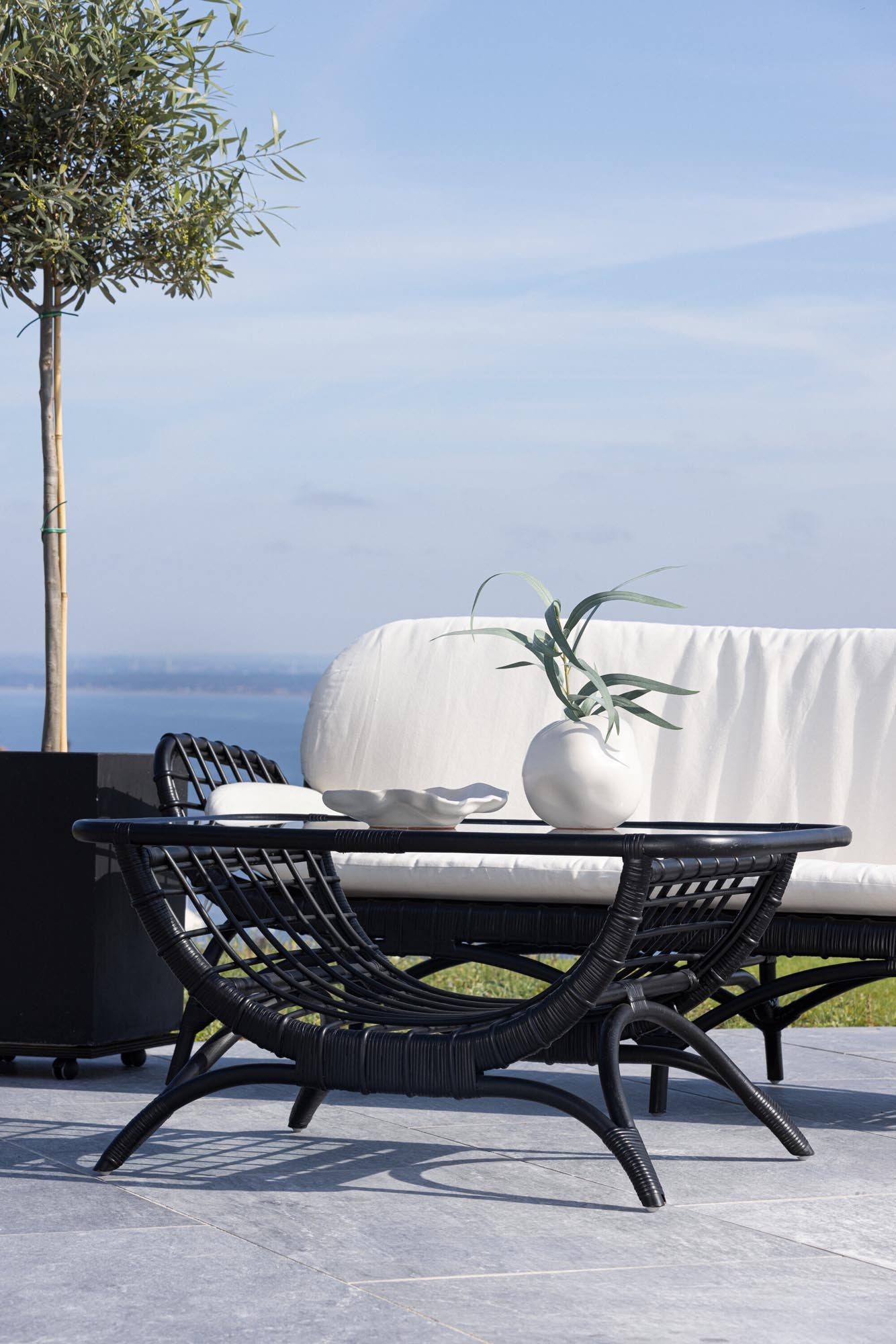 Entdecken Sie den Moana Beistelltisch von Venture Home – ein eleganter Rattan-Tisch mit Glastischplatte, ideal für Ihren Außenbereich.