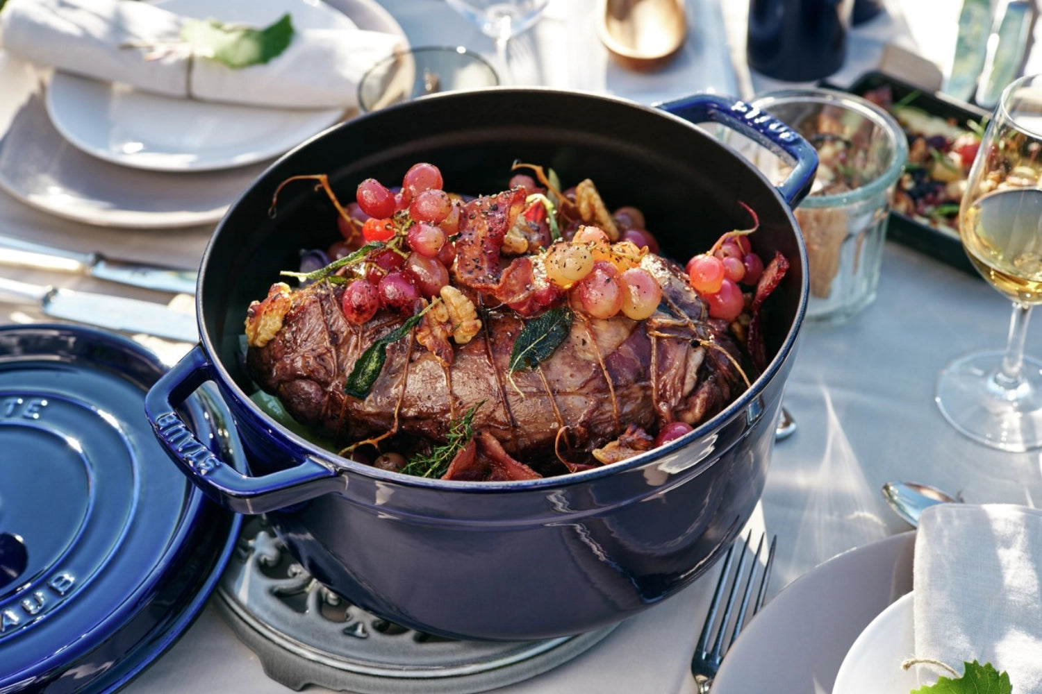 Dunkelblaue Cocotte von Staub, 28 cm, rund, aus Gusseisen, 6.7l, ideal für schmackhafte Gerichte und stilvolle Tischpräsentation.