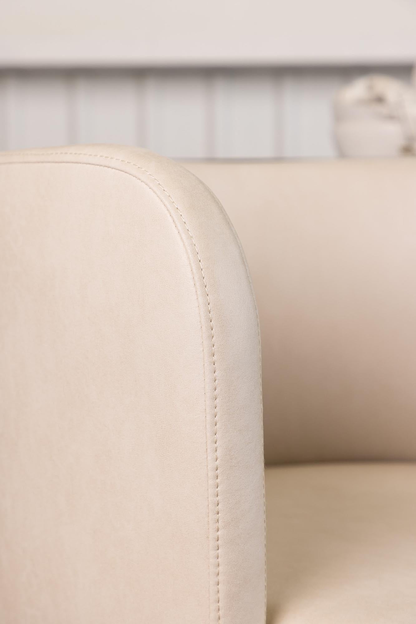Eleganter Schalenstuhl Simrishamn in sanftem Beige, ausgestattet mit bequemen Armlehnen, ideal für stilvolle Wohnräume von Furniture Fashion.