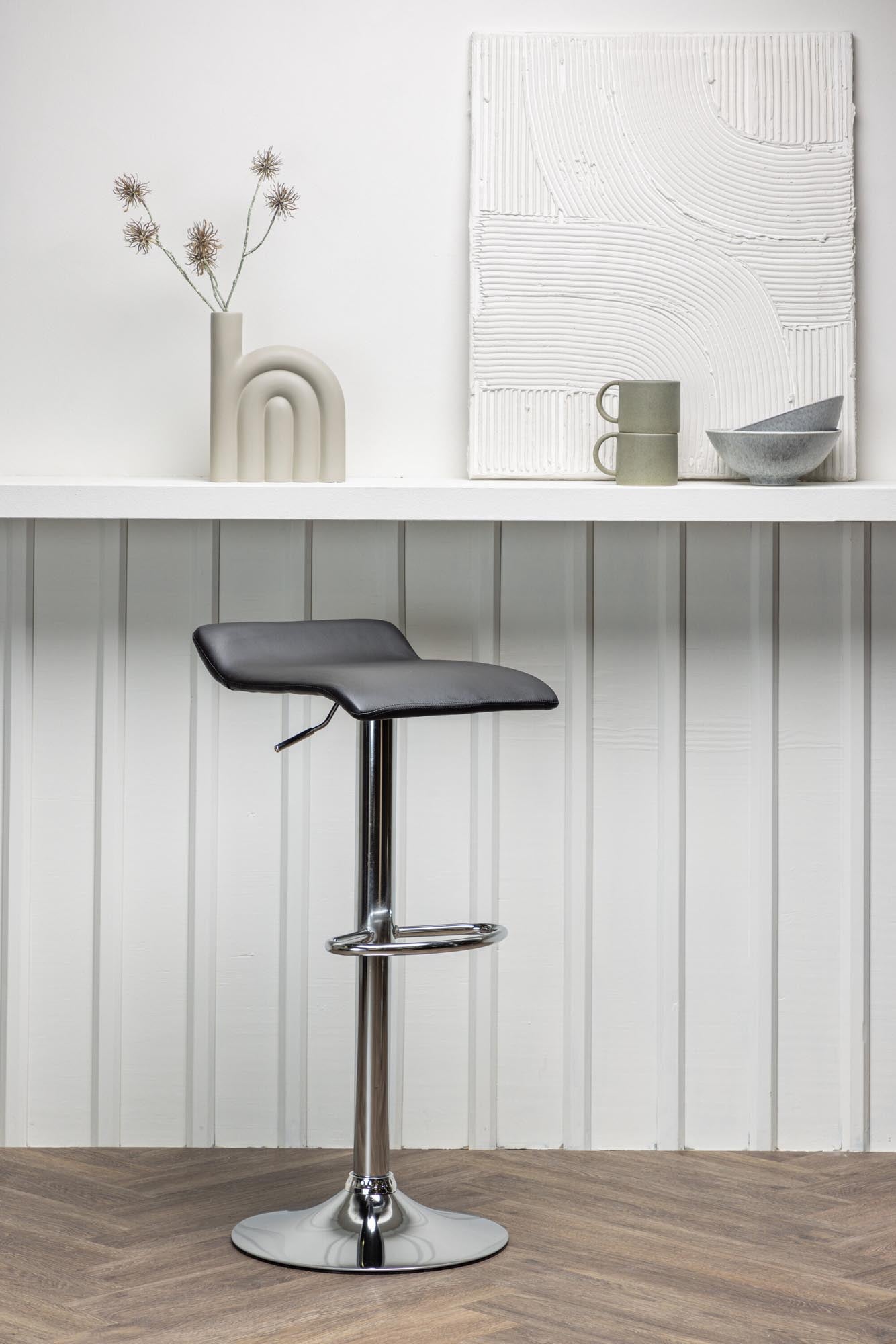 Der Jonna Barstuhl von Venture Home: zeitloses Design, verchromter Trompetenfuss, schwarzes Kunstleder, stilvoll und komfortabel.