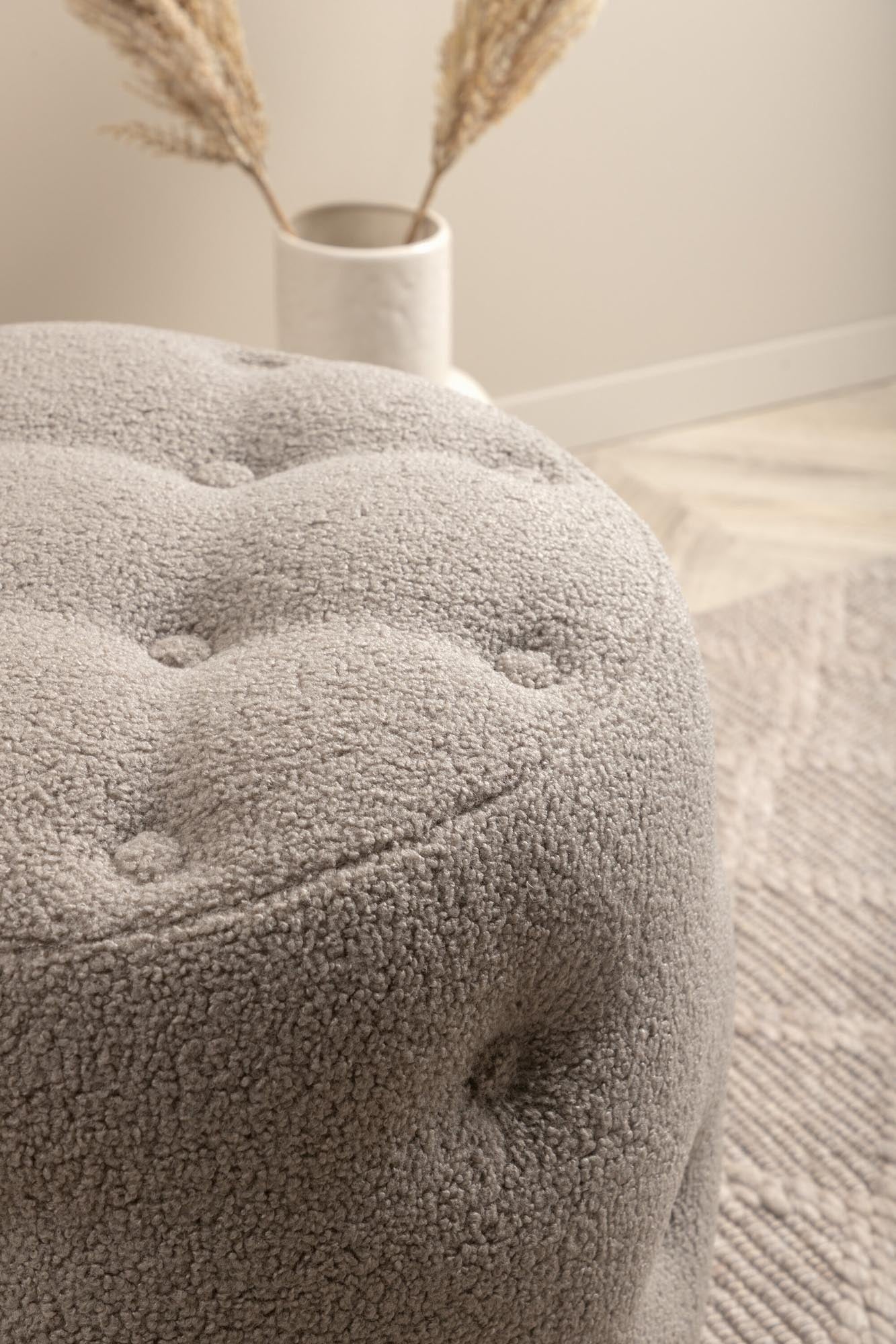 Der Benjamin Ottoman / Pouf von Venture Home ist ein elegantes Möbelstück in sanftem Beige, das Komfort und Stil vereint. Perfekt als Sitzgelegenheit oder Fußhocker.