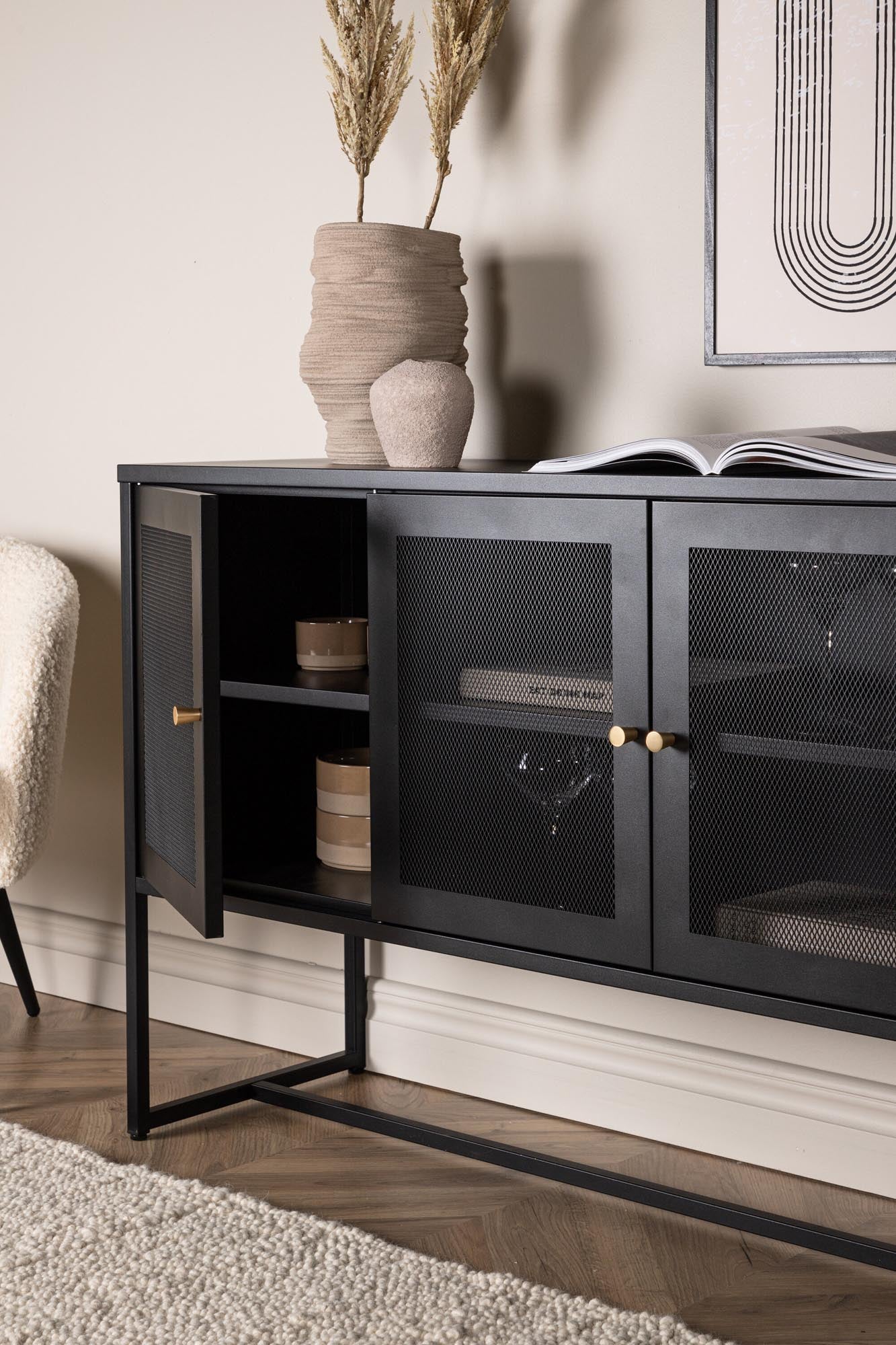 Malla Kabinett: Stilvolles Industriedesign mit Netztüren, stabilen Stahlbeinen und geräumigen Regalen für vielseitige Nutzung.