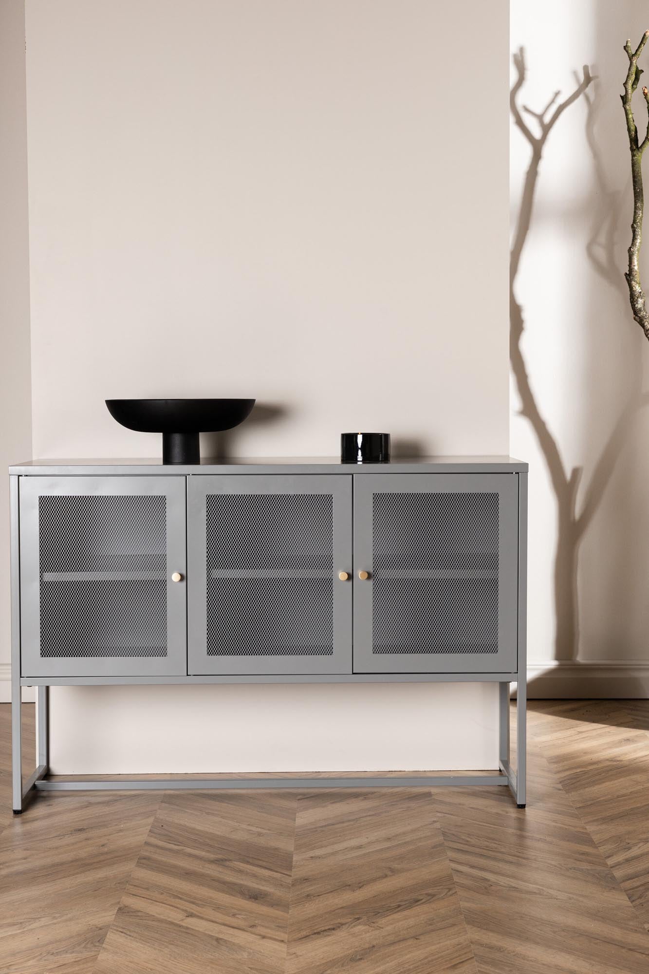 Entdecken Sie das Malla Kabinett von Venture Home: Ein modernes Möbelstück mit stabilen Stahlbeinen, netzartigen Türen und vielseitigen Aufbewahrungsmöglichkeiten.