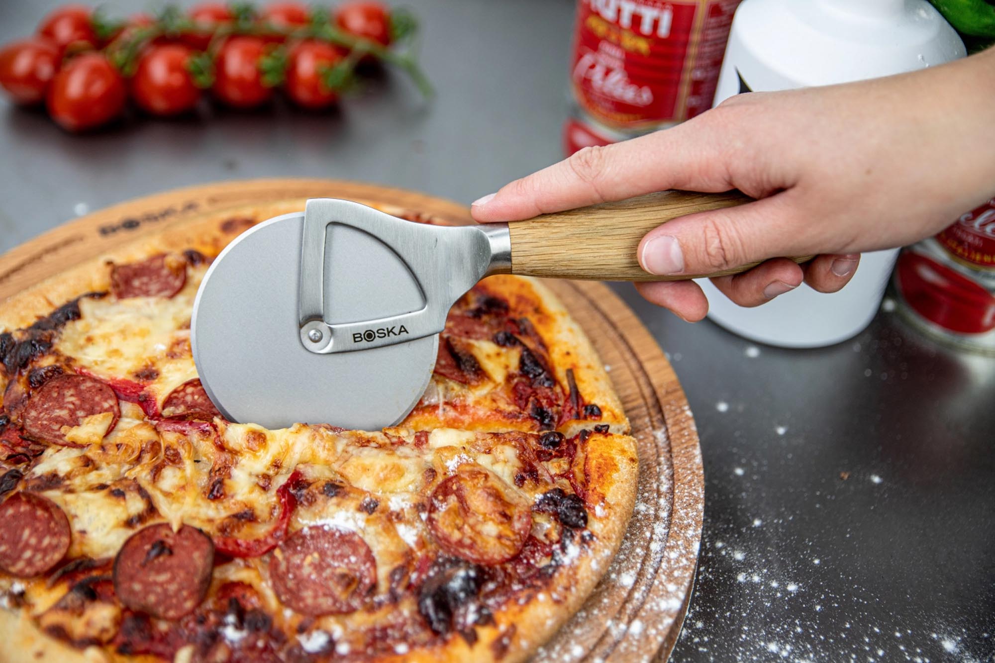 Entdecken Sie das Boska Pizzarad Oslo+: Hochwertiger Edelstahl, ergonomischer Eichenholzgriff, müheloses Schneiden für perfekte Pizzastücke.