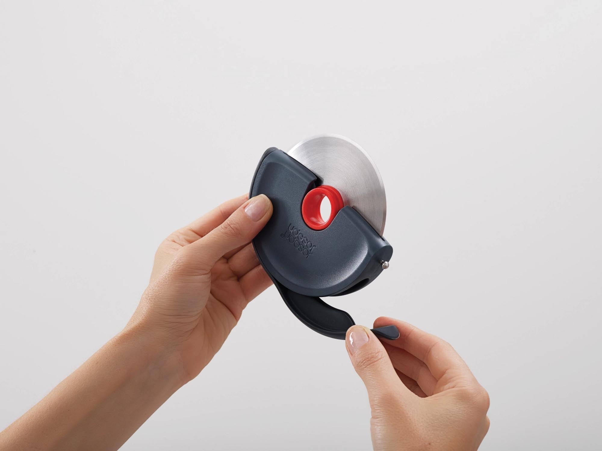 Innovatives Pizzarad mit Silikonschutz von Joseph Joseph in modernem Grau-Rot. Ideal für müheloses Schneiden und stilvolle Küchenorganisation.