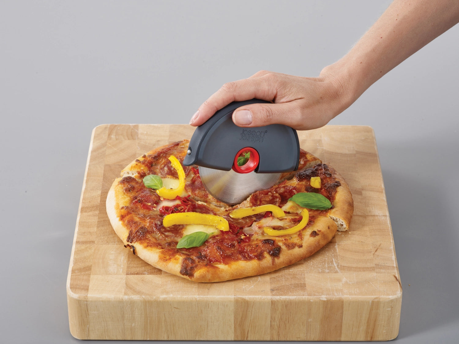 Disc Pizzarad mit Silikonschutz in Grau-Rot, 12x10.7x1.8 cm, von Joseph Joseph – ideal zum Schneiden und Servieren von Pizza.