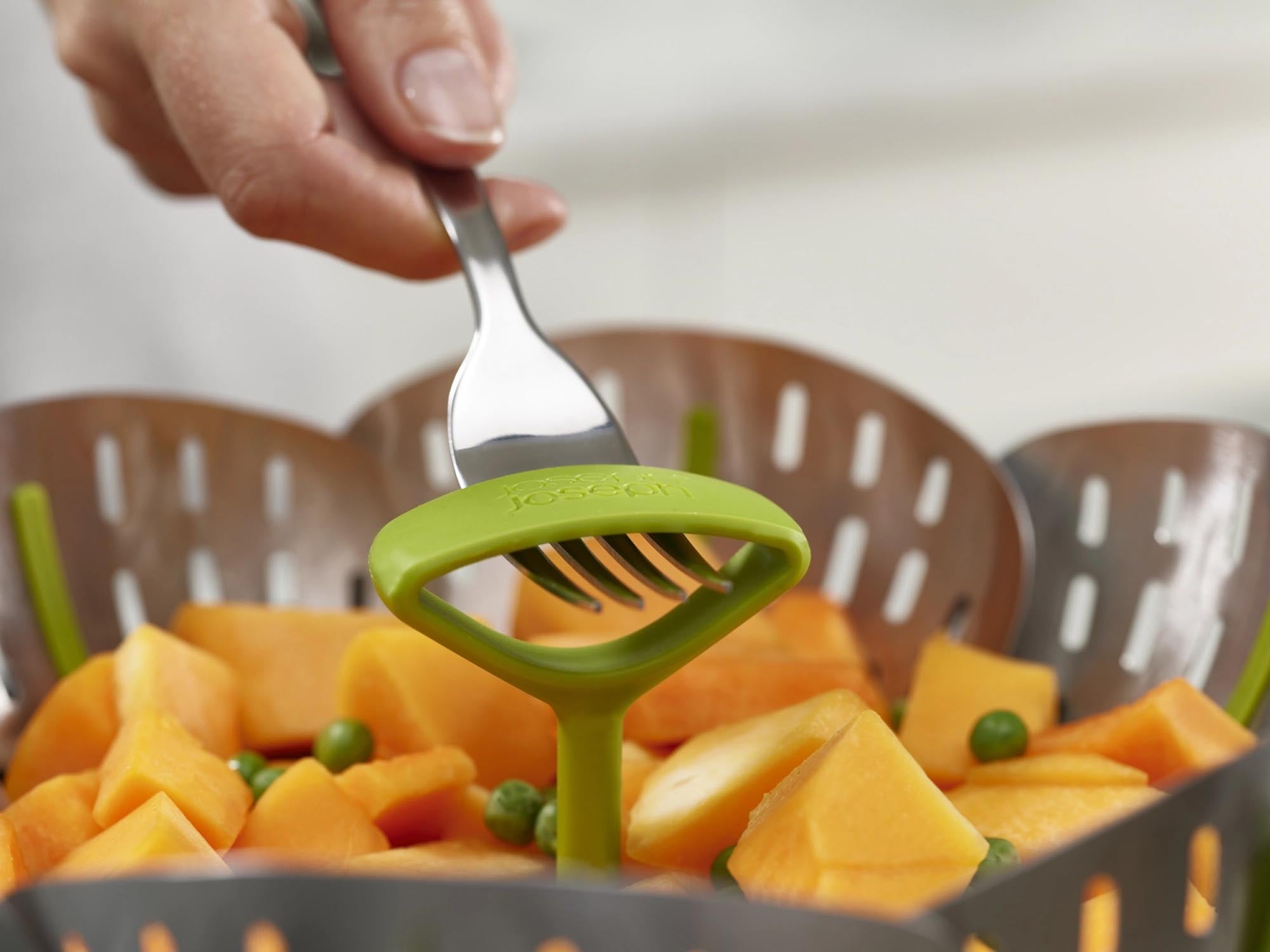 Entdecken Sie den Bloom Steel Dampfgarein von Joseph Joseph: Ein eleganter, zusammenklappbarer Dampfgarer aus Edelstahl in modernem Grün für gesunde Küche.