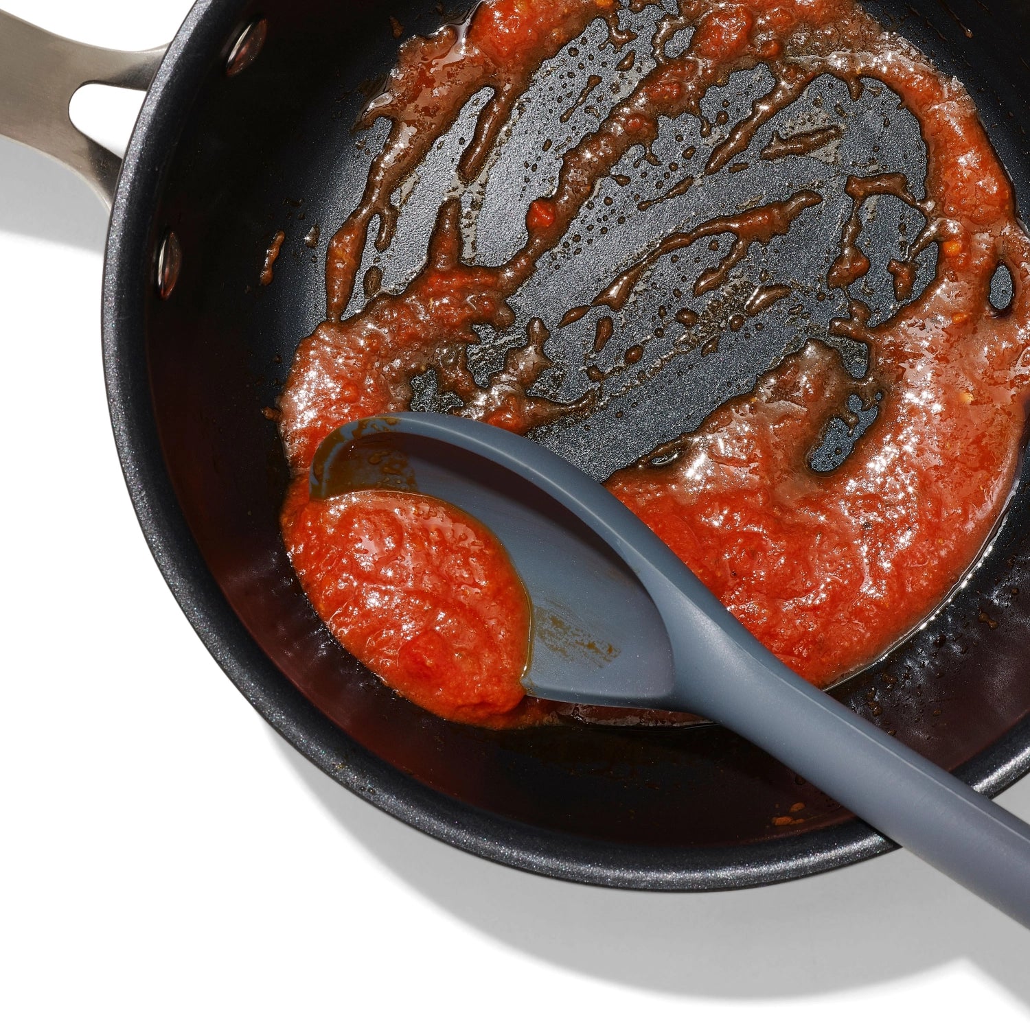 Leuchtend roter Silikonlöffel von OXO, ideal zum Kochen. Hitzebeständig und geschmeidig, perfekt zum Mischen und Servieren von Gerichten.
