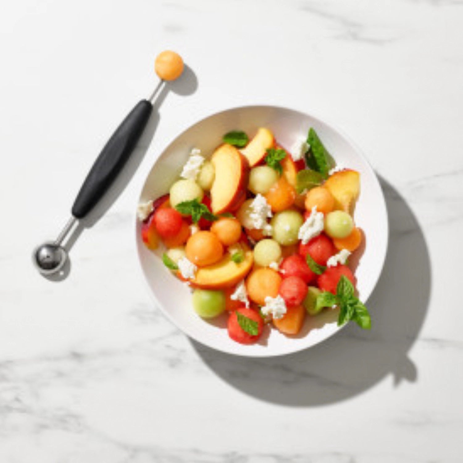 Schwarzer Kugelausstecher von OXO, ideal zum Formen von Obstkugeln für kreative Präsentationen und köstliche Desserts.