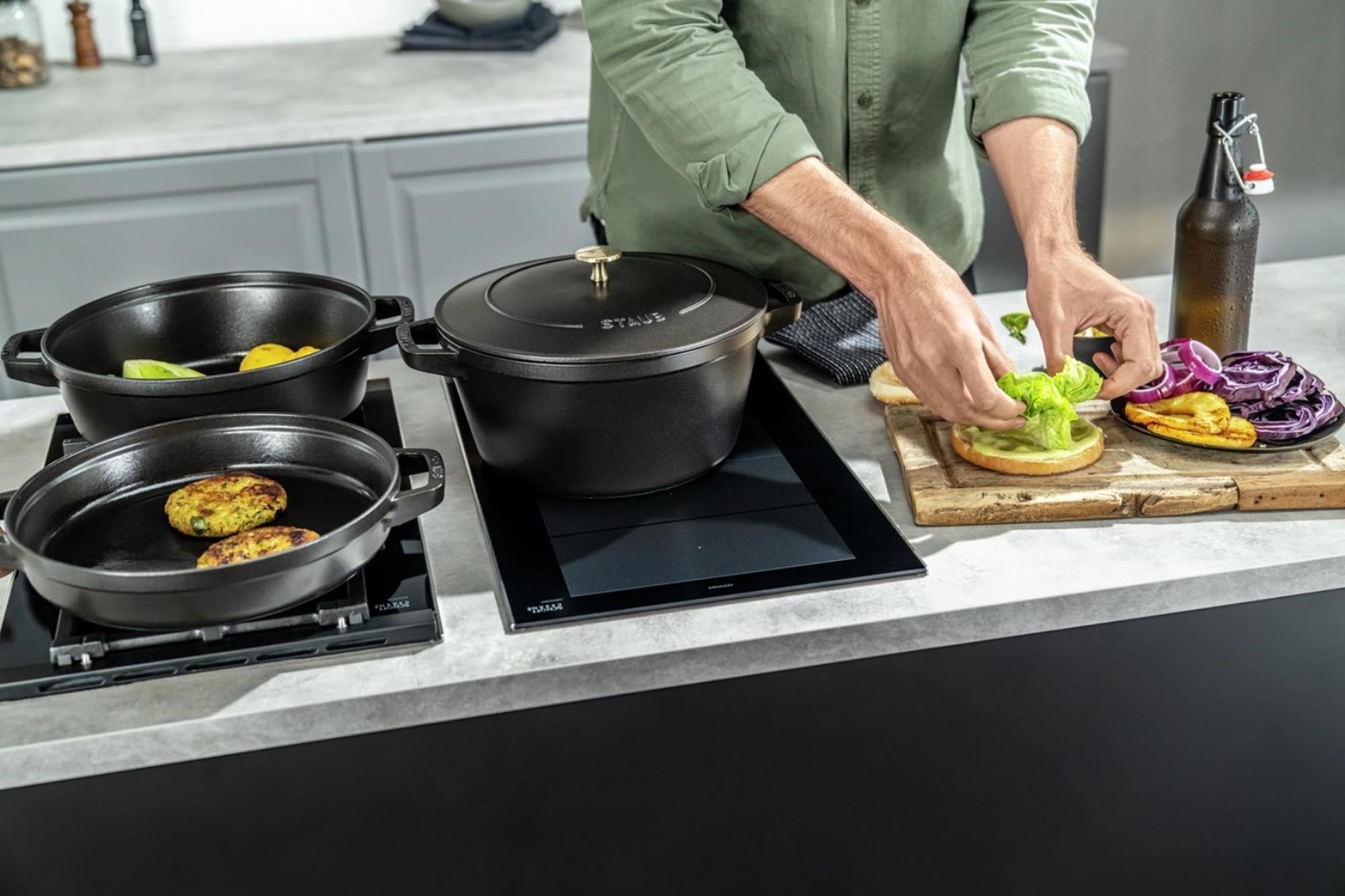 Runde, schwarze Cocotte von Staub, 24 cm, aus Gusseisen, stapelbar, für Eintöpfe, Suppen, Aufläufe, Induktion geeignet.