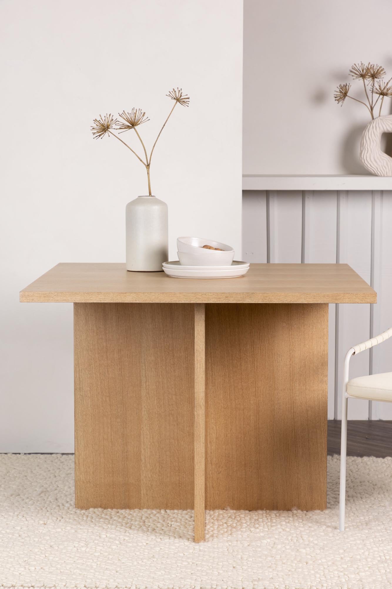 Entdecken Sie den Leo Tisch von Venture Home: Zeitloses Design, stabile Eichenfarbe und großzügige Tischplatte für gesellige Momente in kleinen Küchen.