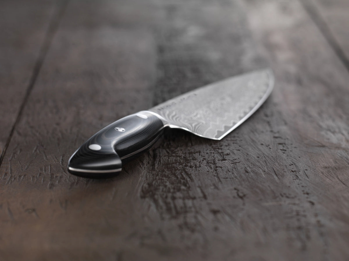 Zwilling Kramer Euro Stainless Kochmesser mit 16cm langer Damaststahlklinge und schwarzem Griff aus Leinen-Micarta, Mosaikstift sichtbar.