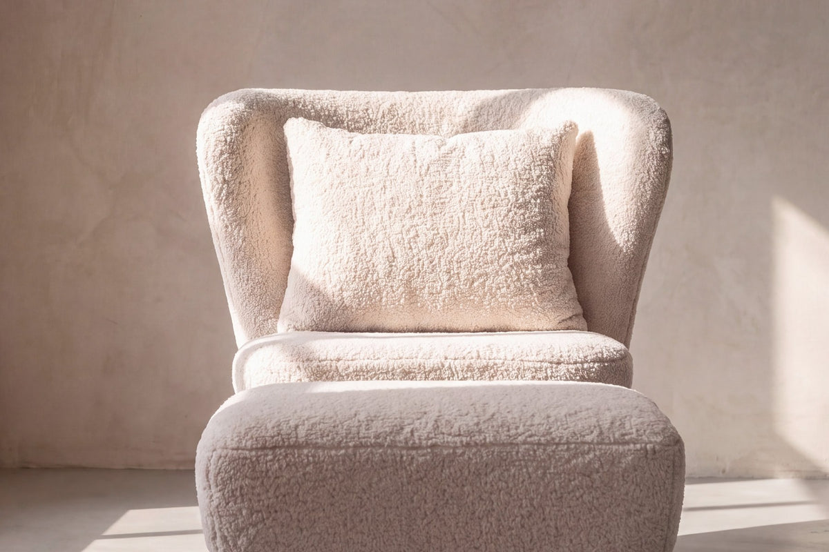 Weisser Loungesessel mit Bouclé-Bezug aus Polyester, Schaumstofffüllung und braunen Stahlbeinen im Holzeffekt-Design, Sitzhöhe 43 cm.