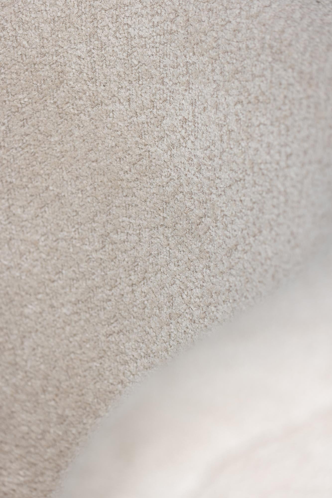 Der Hällsö Sessel von Vind vereint modernes Design mit Komfort. Der bequeme Bezug aus Boulé-Stoff und die Walnussholzbeine machen ihn zum perfekten Möbelstück für jede Leseecke.