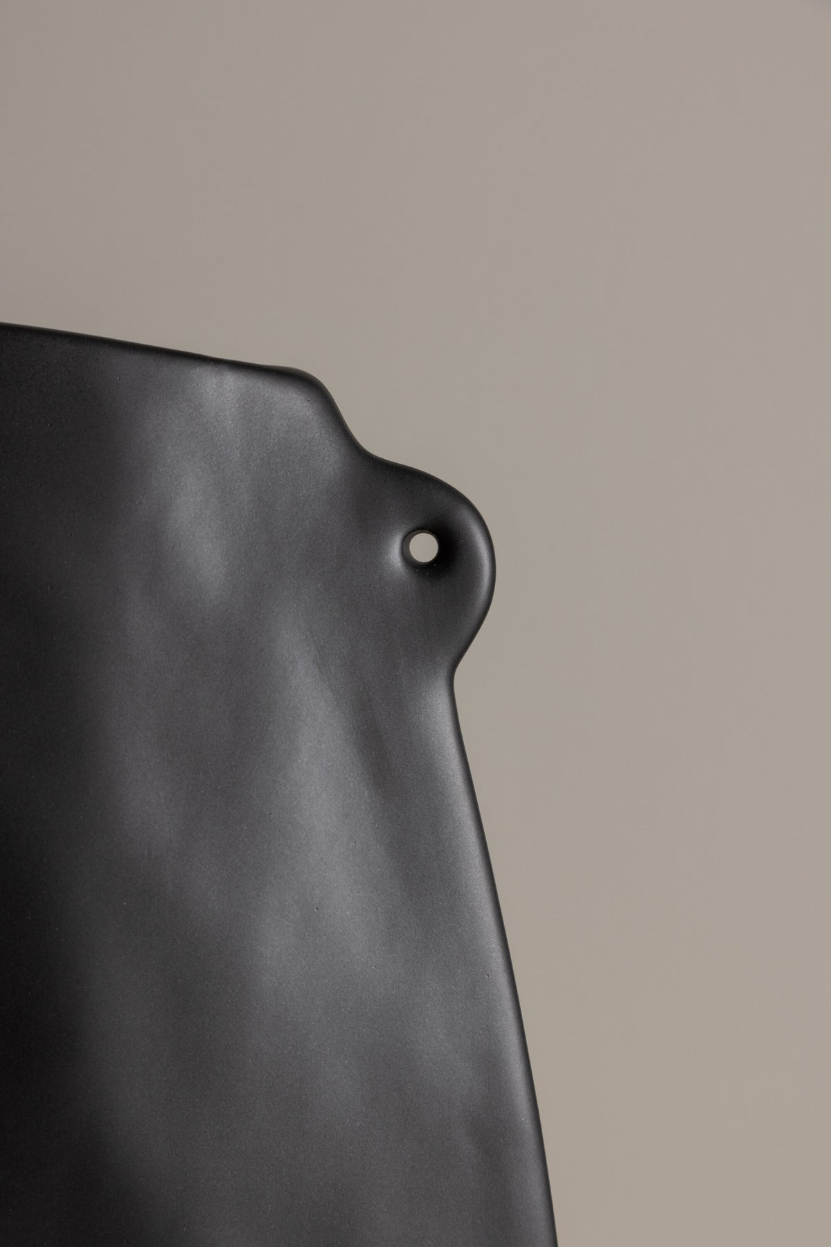 Schwarze Hie Vase von Venture Home aus Steinzeug mit schmaler Öffnung und zwei seitlichen Griffen, freigestellt fotografiert.