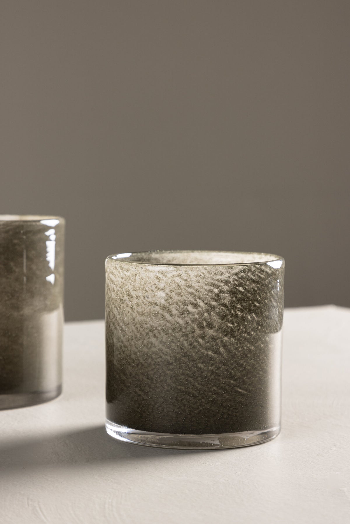 Weisser runder Teelichthalter Glora aus Glas, Durchmesser 8 cm, Höhe 8 cm, schlichte, transparente Oberfläche mit dünner Wandstärke.