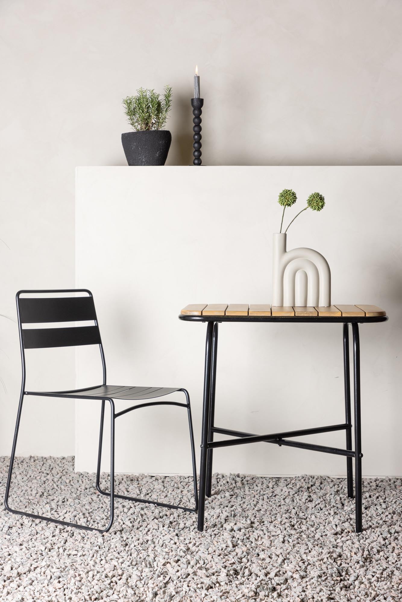 Entdecken Sie den Holmbeck Café Tisch von Venture Home: Robustes Akazienholz trifft eleganten Stahl. Perfekt für entspannte Stunden im Freien.