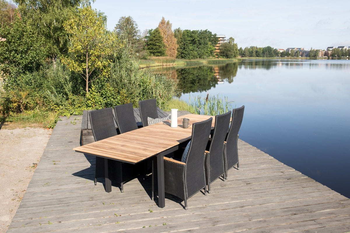 Rechteckiger Gartentisch Mexiko mit naturfarbener Teakholz-Tischplatte und schwarzem Aluminiumgestell, ausziehbar, im Freien aufgestellt.