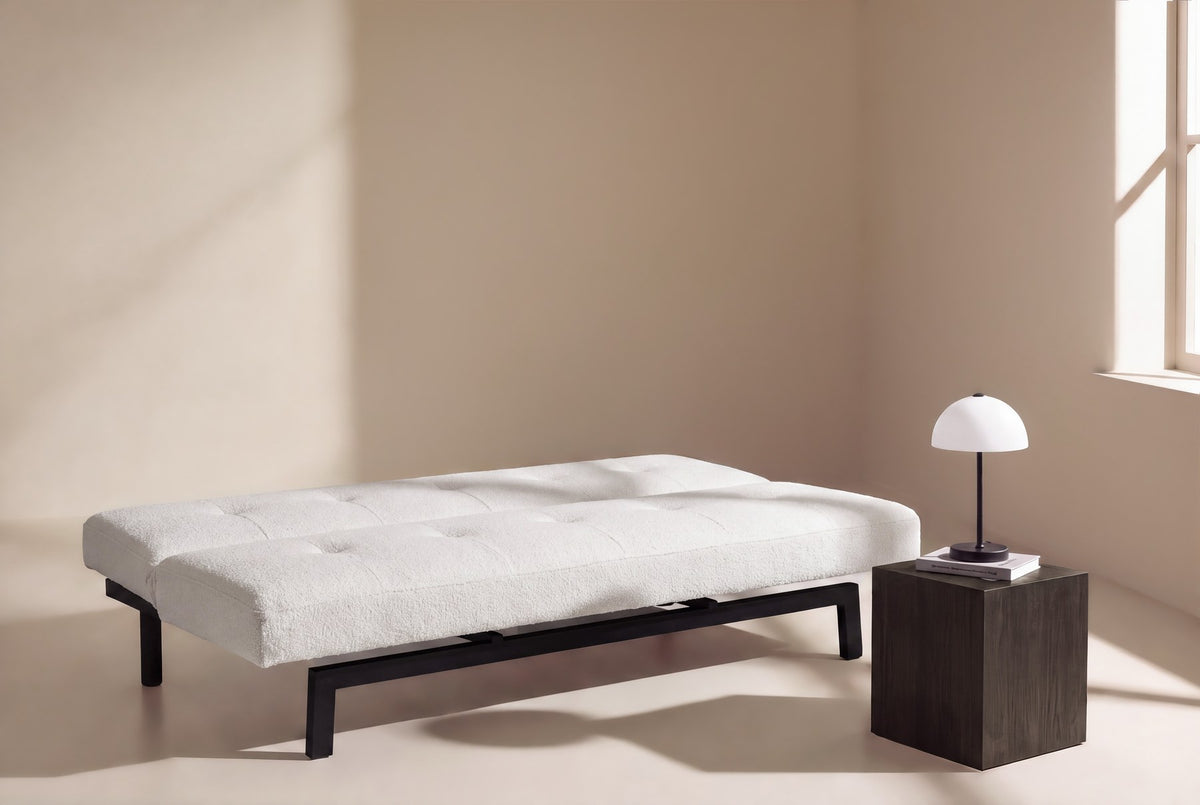 Weisses Klappbett Bodil von Venture Home mit Teddy-Bezug, schwarzen Stahlbeinen und schlichtem Steppmuster als Bettsofa dargestellt.