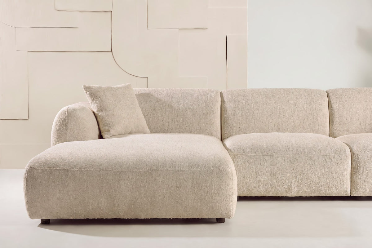 Beiges Chaiselongue-Sofa mit L-Form, Polyester-Bezug, schwarzen Holzbeinen und rechtsseitiger Chaiselongue, freigestellt fotografiert.