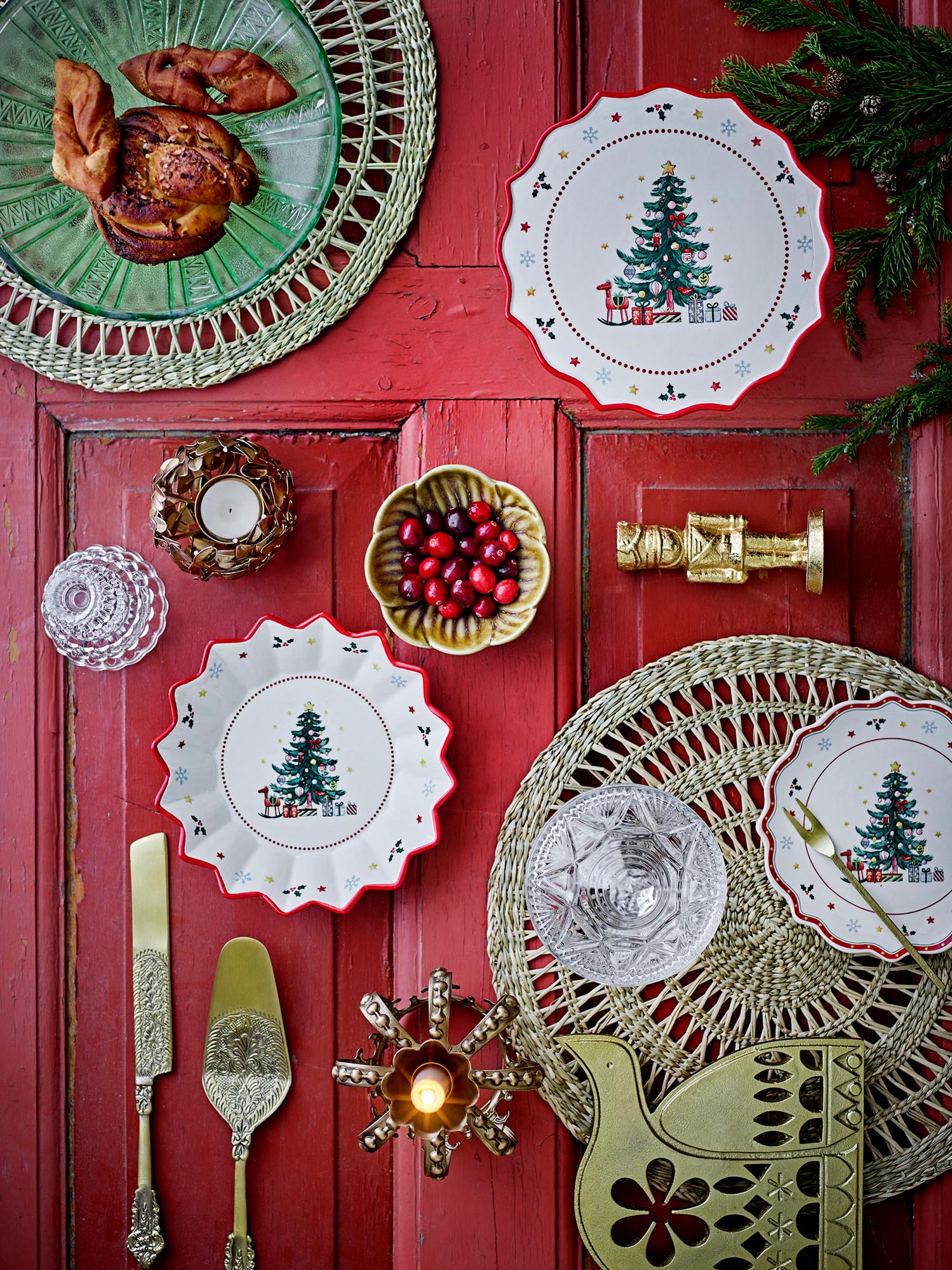 Ein handbemalter Keramikteller mit festlichem Weihnachtsbaum-Motiv und rotem Rand, ideal für die festliche Tafel.