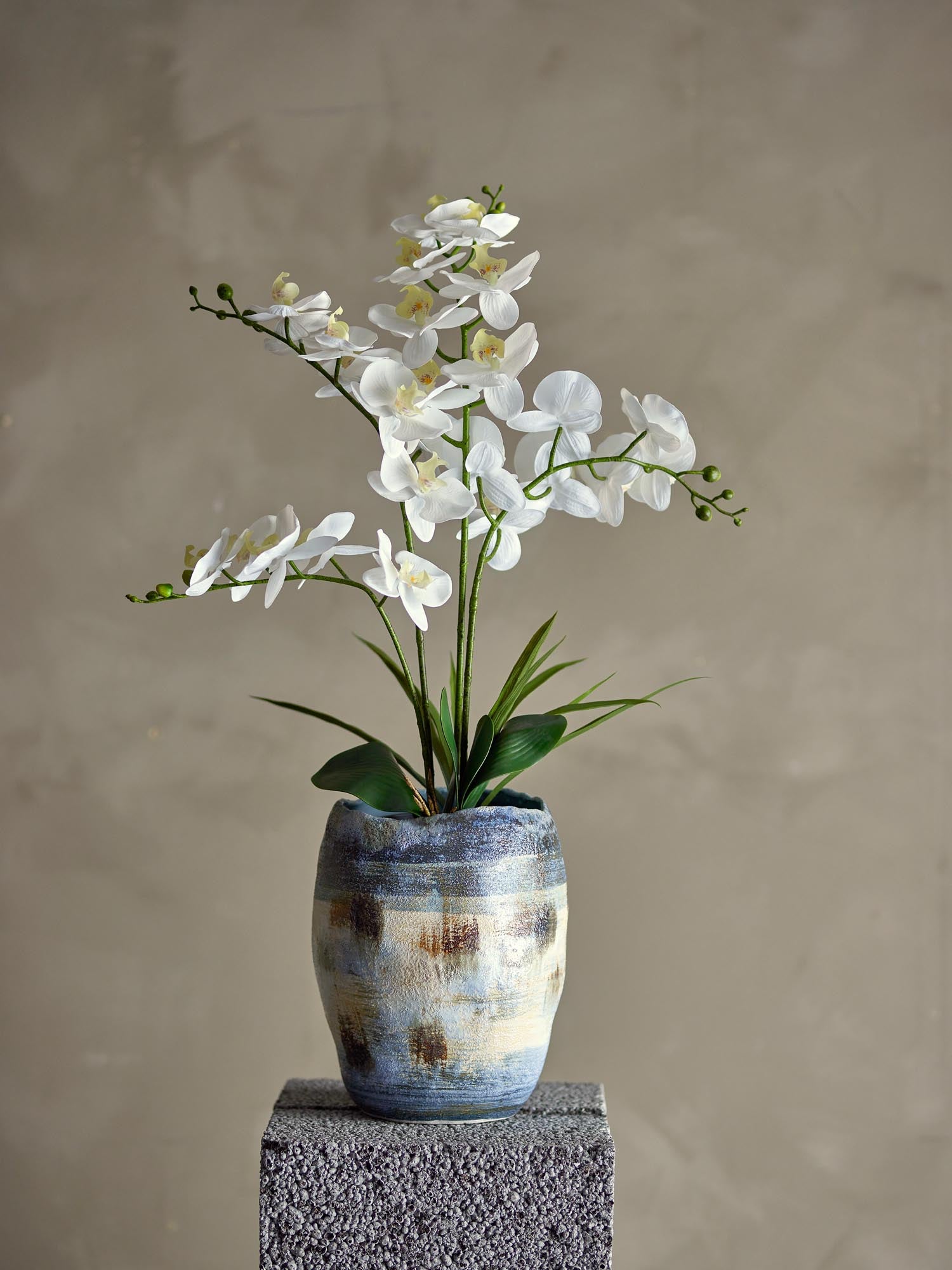 Realistische künstliche Orchidee von Bloomingville mit grünen Blättern und detailgetreuen Blüten, perfekt für moderne Dekoration.