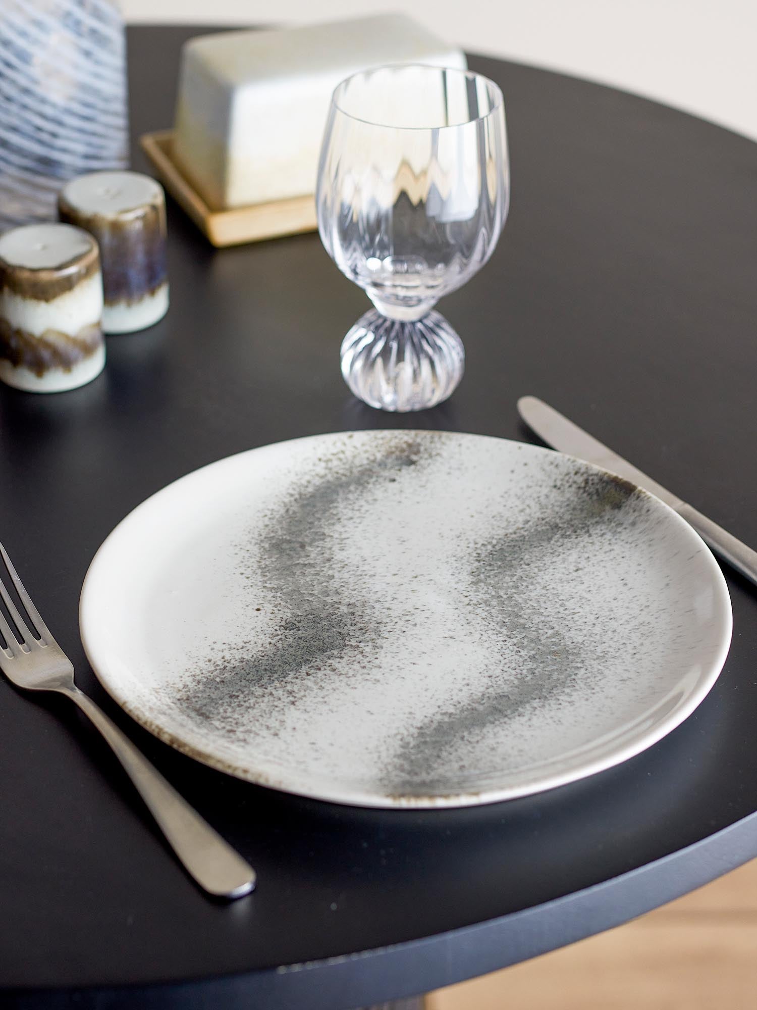 Der graue Paula Teller von Bloomingville aus Steingut überzeugt mit elegantem Design und ist ideal für moderne Tischdekorationen.