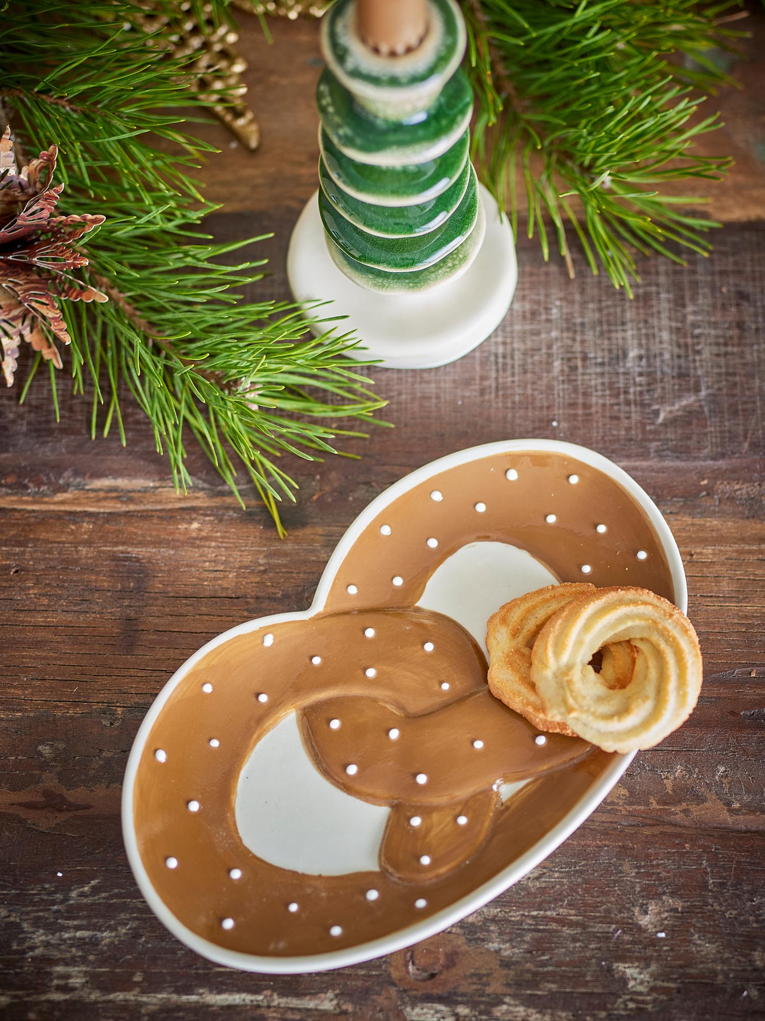 Die braune Steingut-Servierplatte von Bloomingville besticht durch ihr handbemaltes Brezelmotiv und vereint Funktionalität mit stilvollem Design.