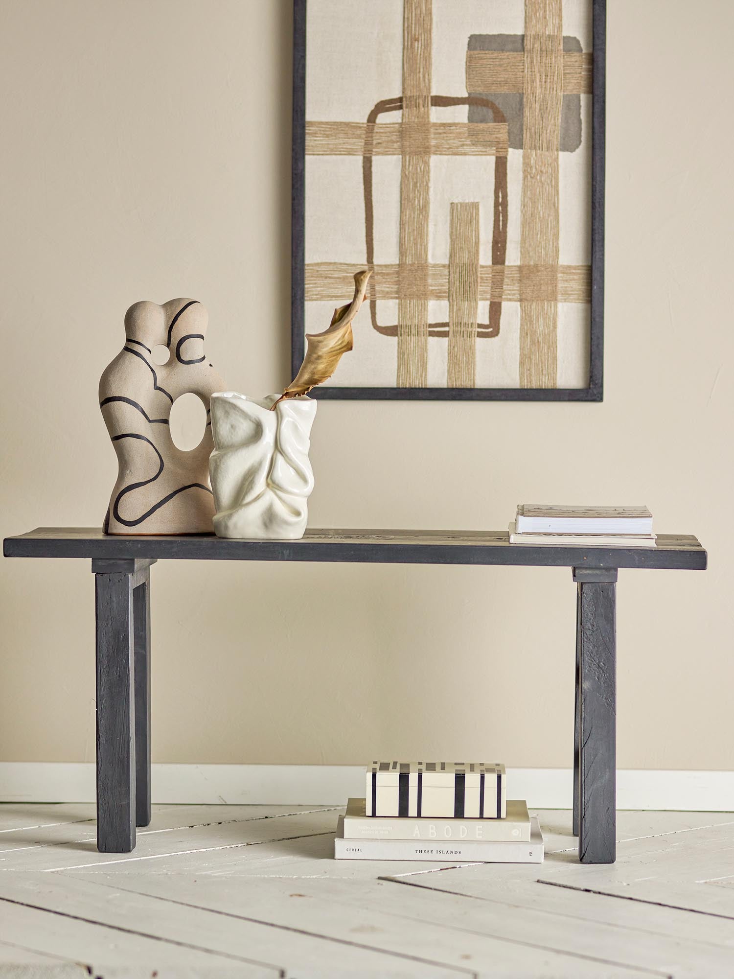 Elegante schwarze Bank aus recyceltem Holz, ideal für kleine Räume, vereint Nachhaltigkeit und zeitloses Design.