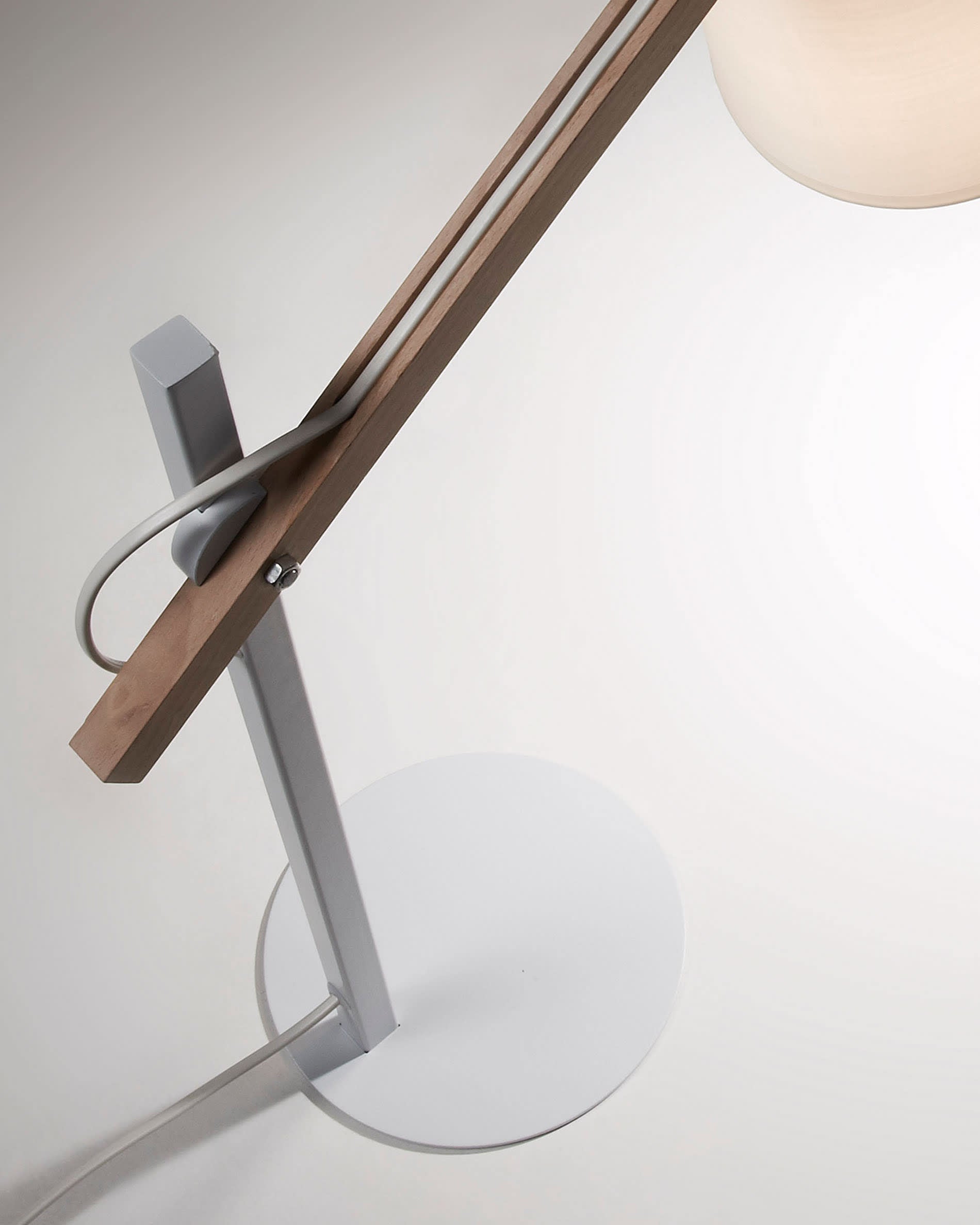 Die Kosta Tischlampe von Kave Home kombiniert Holz und Metall für ein modernes Design und sorgt mit ihrem Baumwollschirm für warmes, gleichmäßiges Licht.