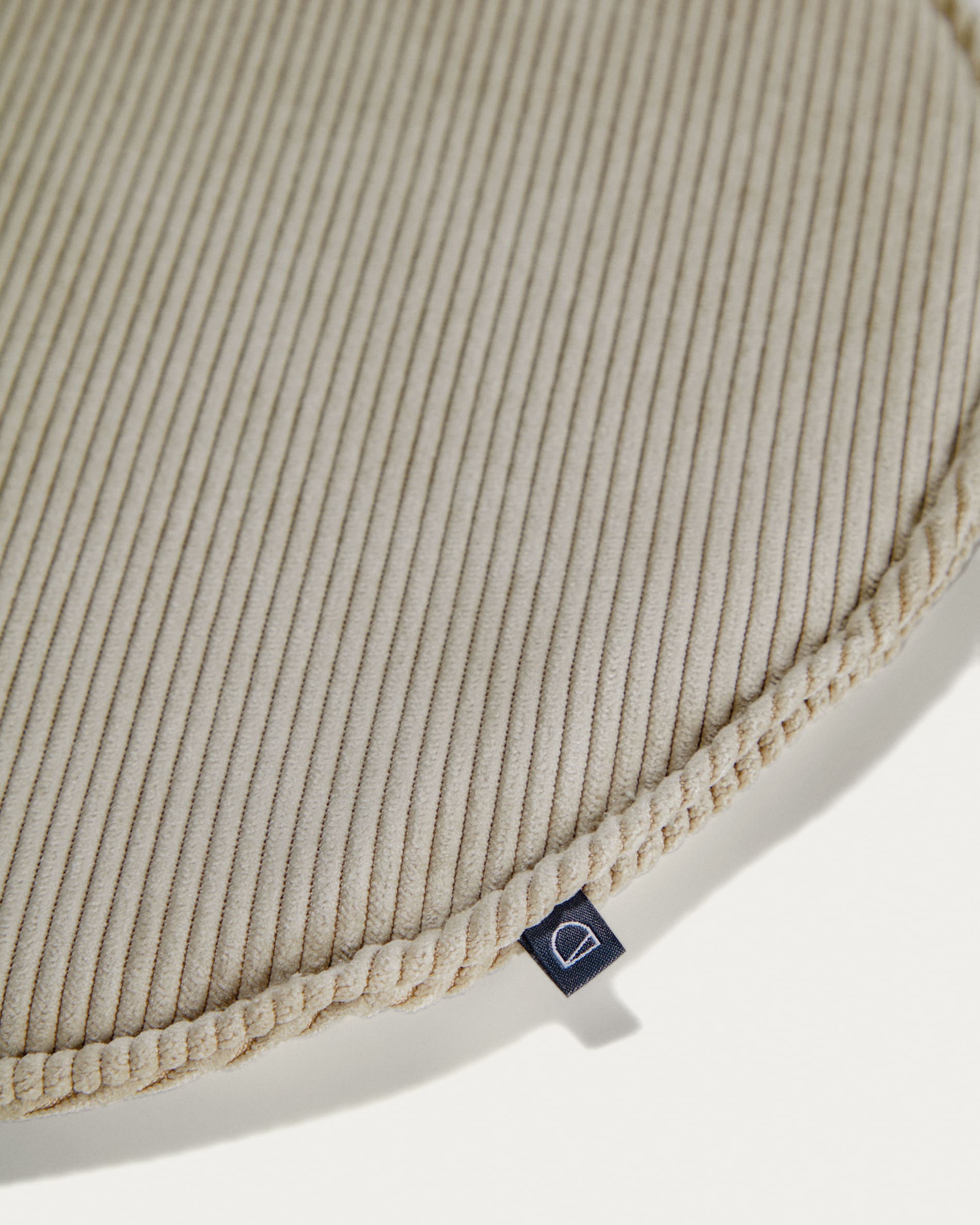 Das Sora Sitzkissen von Kave Home (Ø 35 cm) in taupe bietet mit seinem hochwertigen Cordbezug eine stilvolle und bequeme Sitzgelegenheit für jeden Raum.