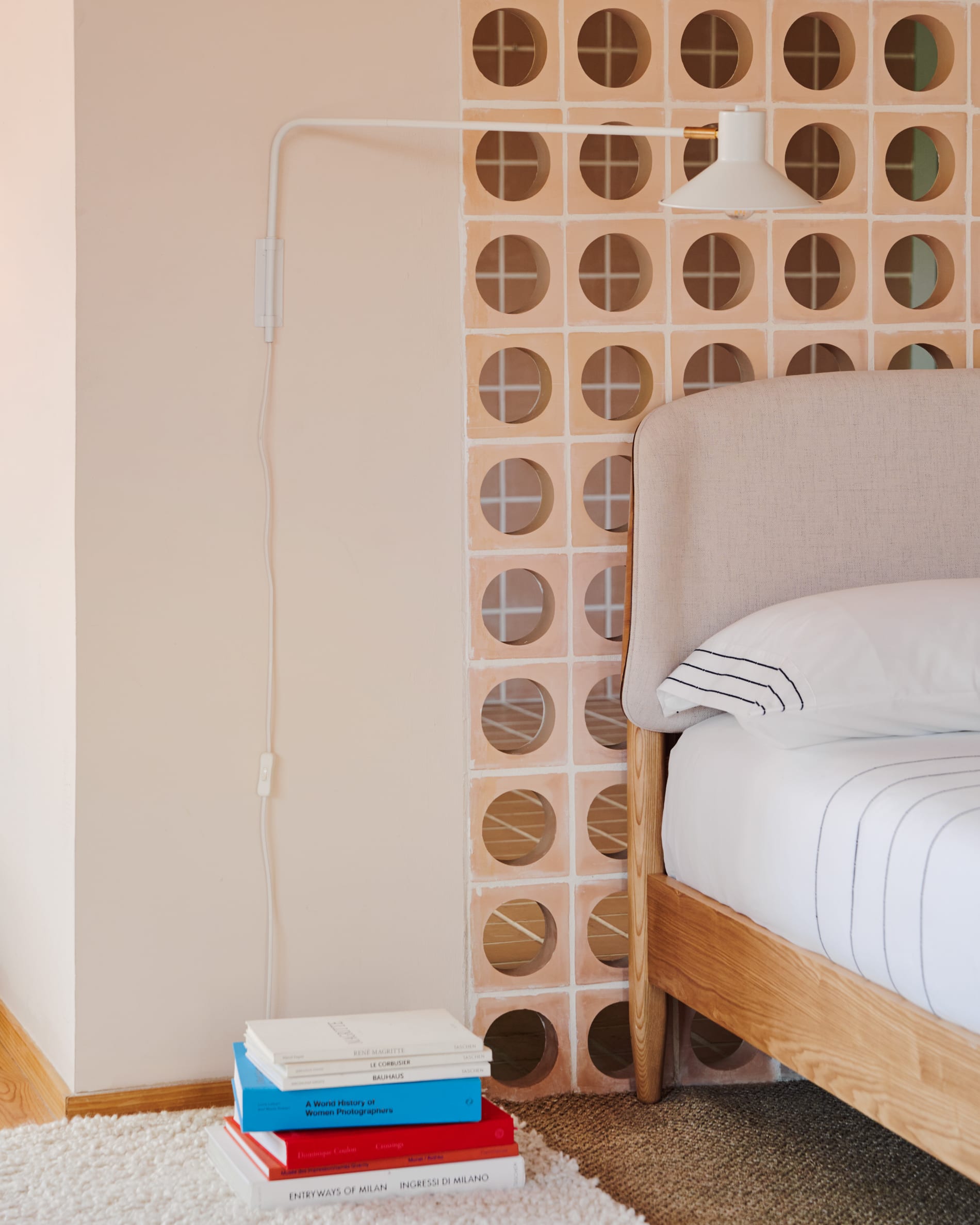 Die Aria Wandleuchte vereint modernes Design mit einem weissen Stahlschirm und eleganten Messingdetails für stilvolle Beleuchtung.