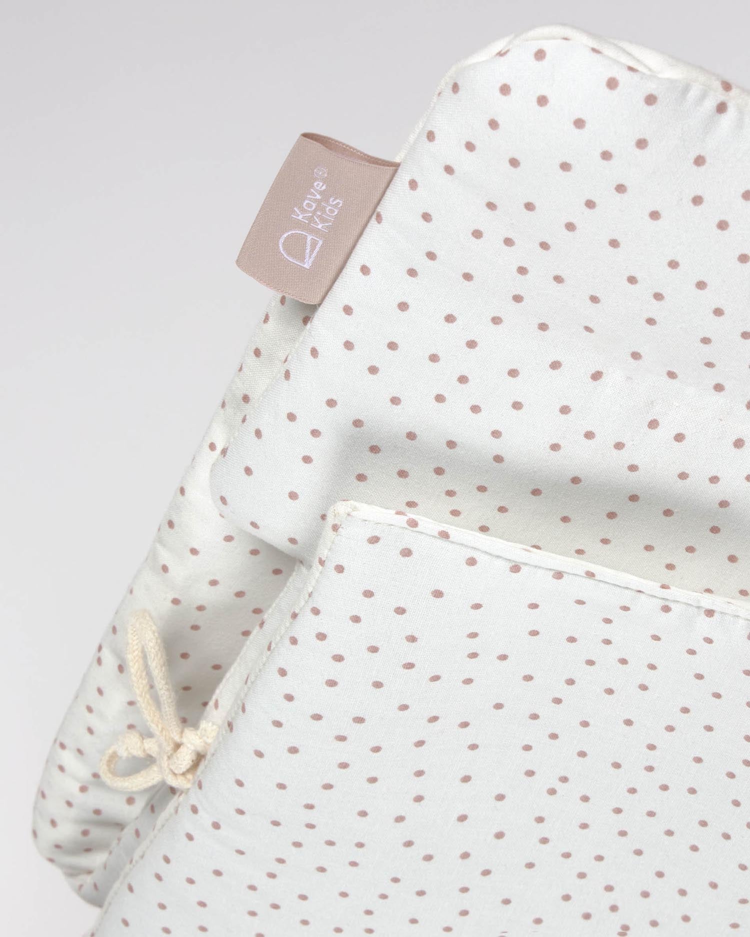 Entdecken Sie das Nuun Hochstuhl Kissen von Kave Home: 100% GOTS-zertifizierte Bio-Baumwolle, charmantes Design mit rosa Punkten, wasserabweisend und pflegeleicht.