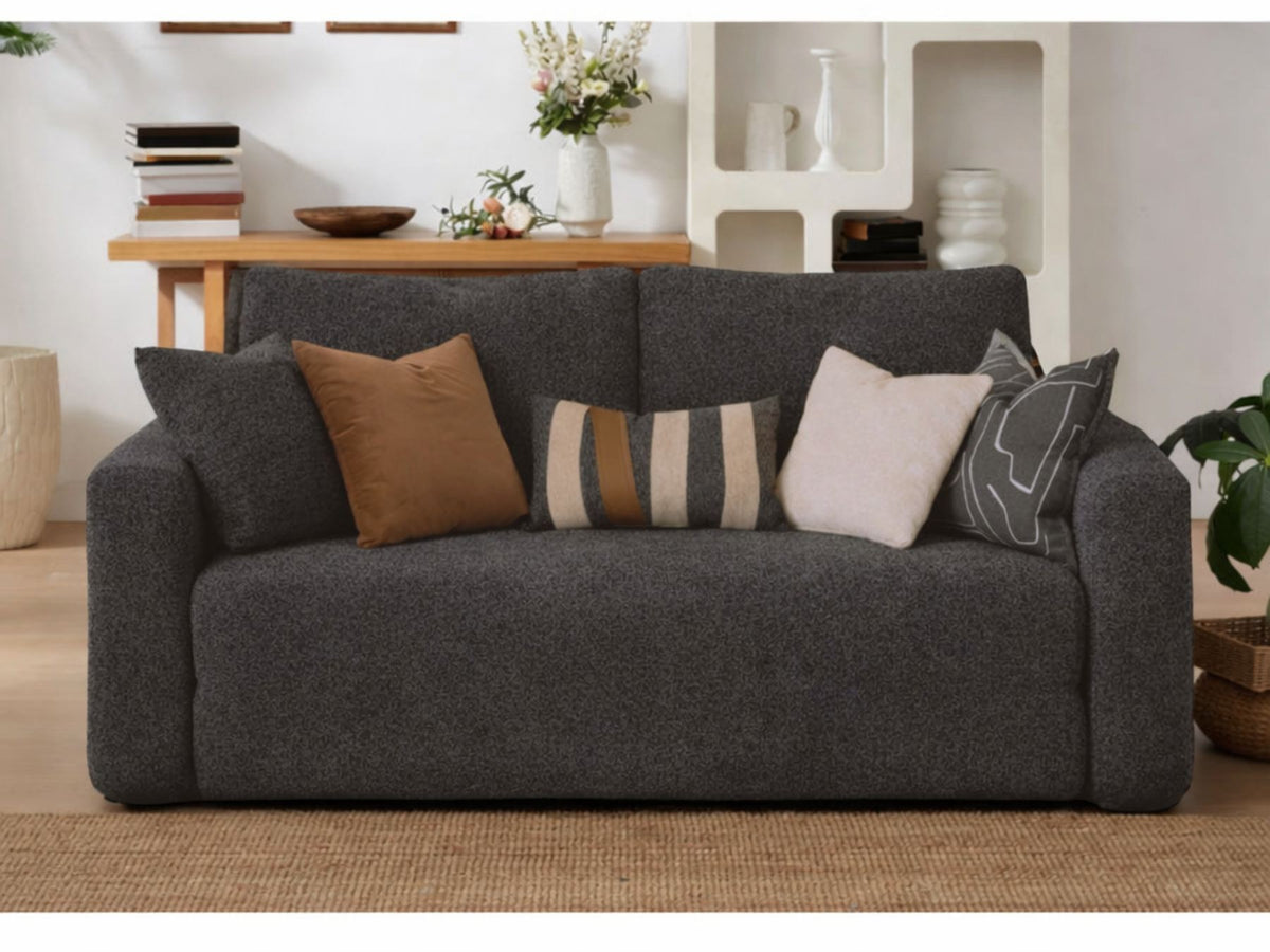 Anthrazitfarbenes 2-Sitzer Schlafsofa Wello aus Bouclé-Stoff mit kompakter Form, Armlehnen und flacher Sitzfläche, aufgestellt im Wohnraum.