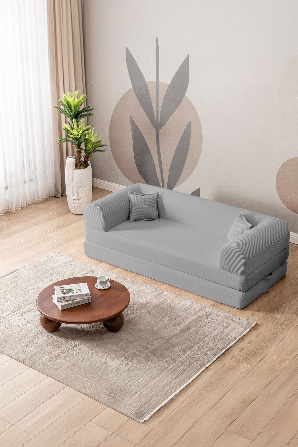 Hellgraues 3-Sitzer Schlafsofa aus geripptem Cord-Plüschstoff mit zwei Kissen, Rollpack-Design und rutschfester Sohle.