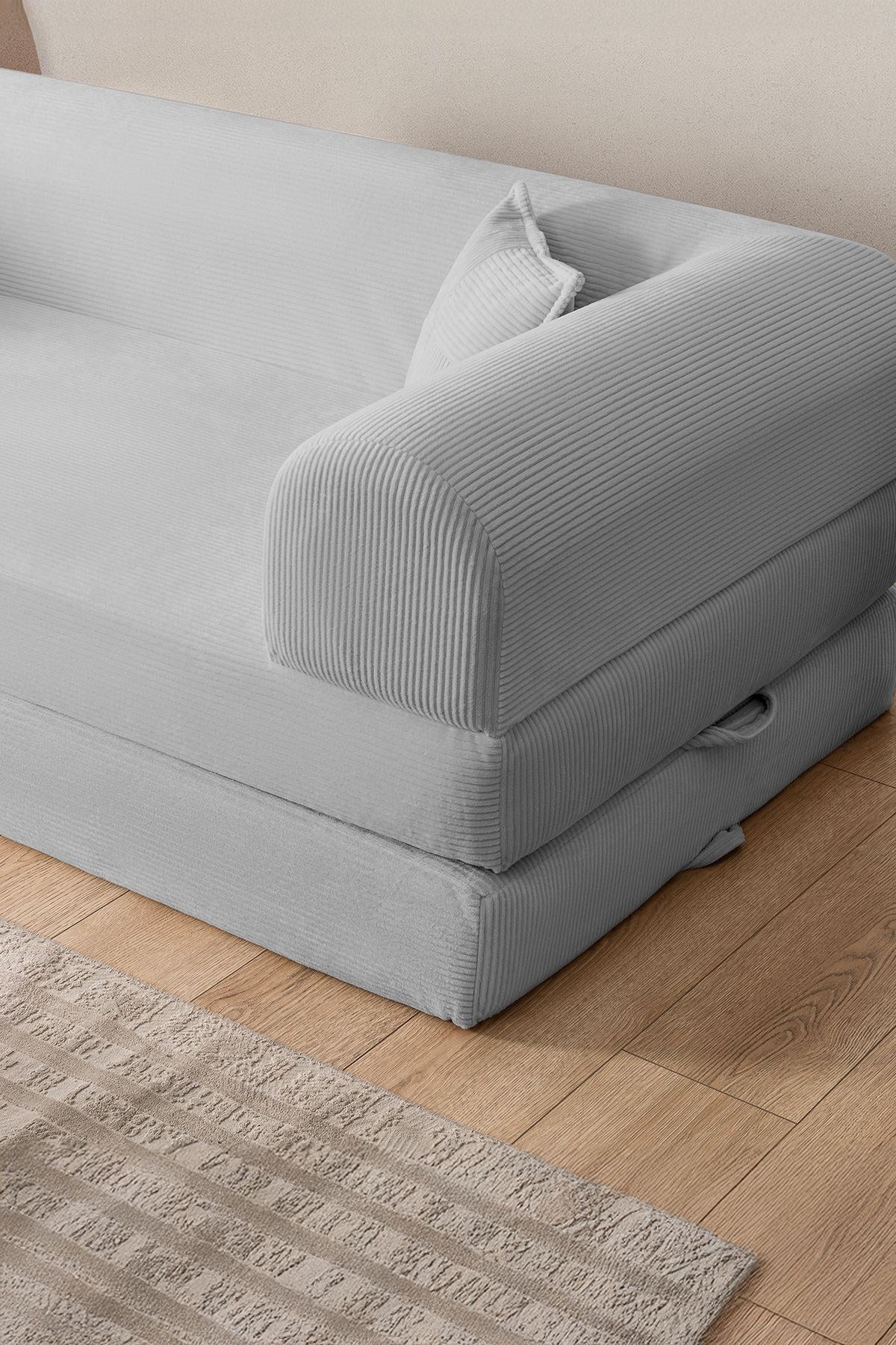 Hellgraues 3-Sitzer Schlafsofa aus geripptem Cord-Plüschstoff mit zwei Kissen, Rollpack-Design und rutschfester Sohle.