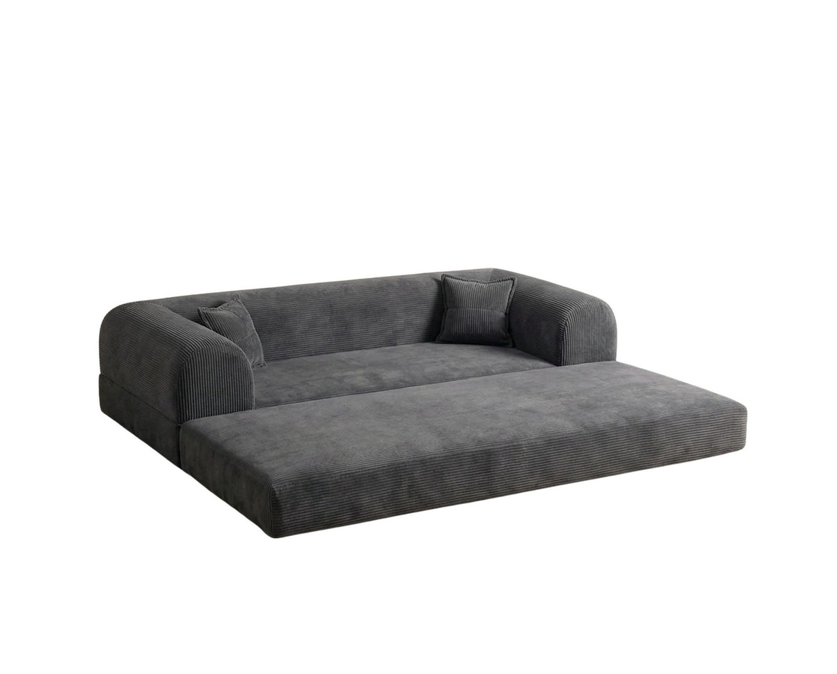 Anthrazitfarbenes 3-Sitzer Schlafsofa aus geripptem Cord-Plüschstoff mit zwei Kissen und sichtbarer rutschfester Sohle.