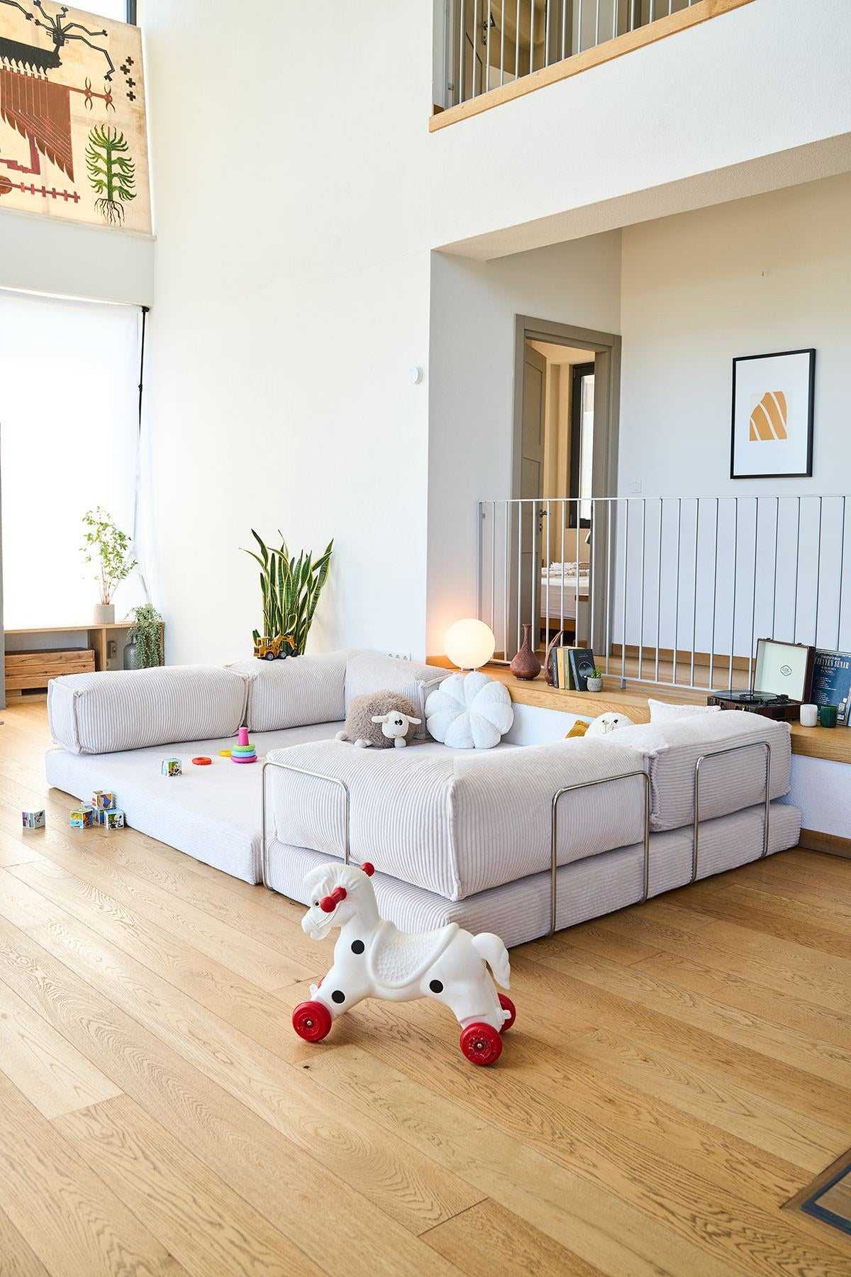 Cremefarbenes Eck-Schlafsofa aus Cord-Plüschstoff mit vier Kissen, rutschfester Sohle und abnehmbarem Bezug, Frontalansicht auf hellem Untergrund.
