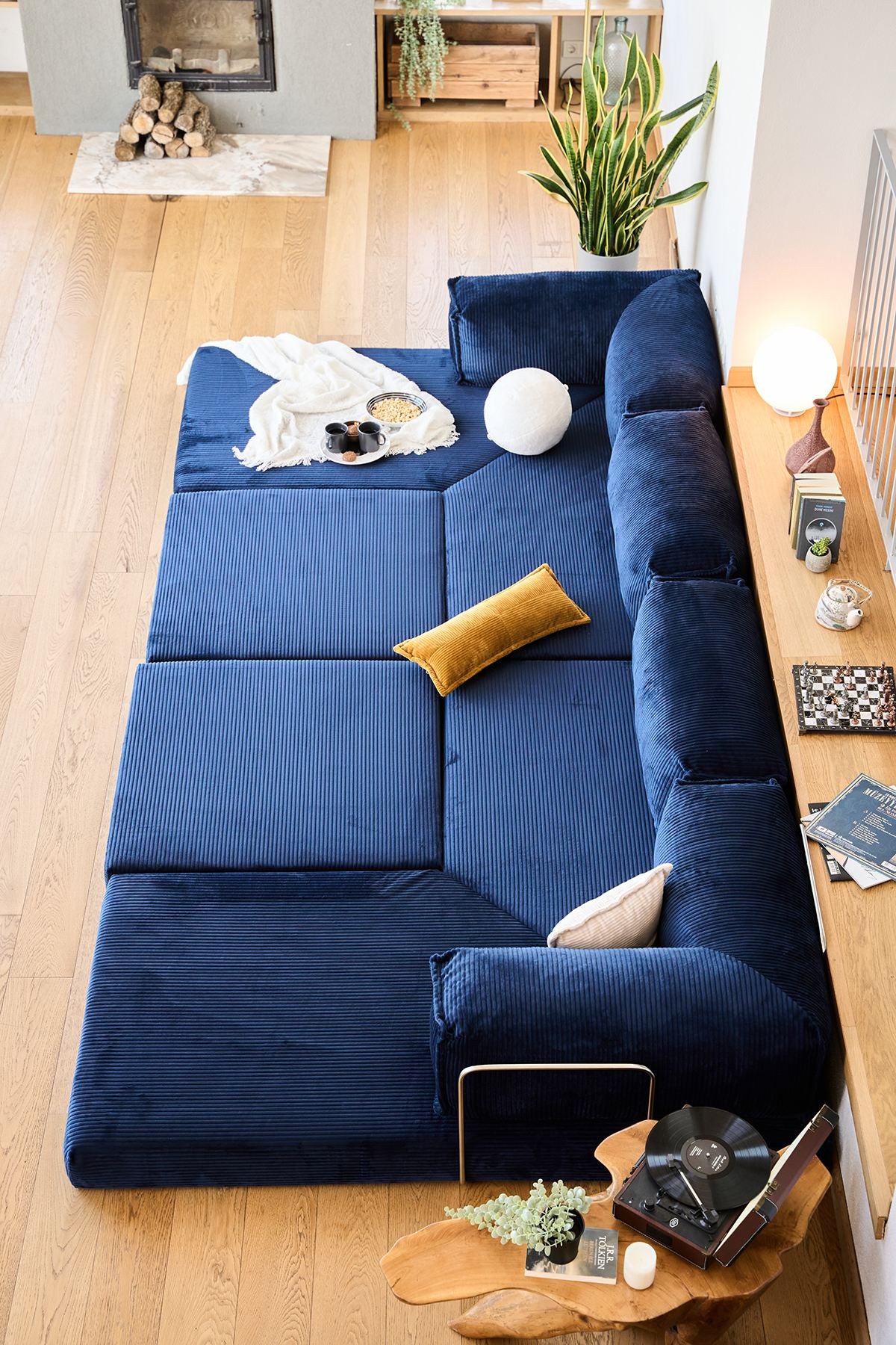 Marineblaues Eck-Schlafsofa aus Cord-Plüschstoff mit vier Kissen, Rollpack-Verpackung und abnehmbarem, waschbarem Bezug.
