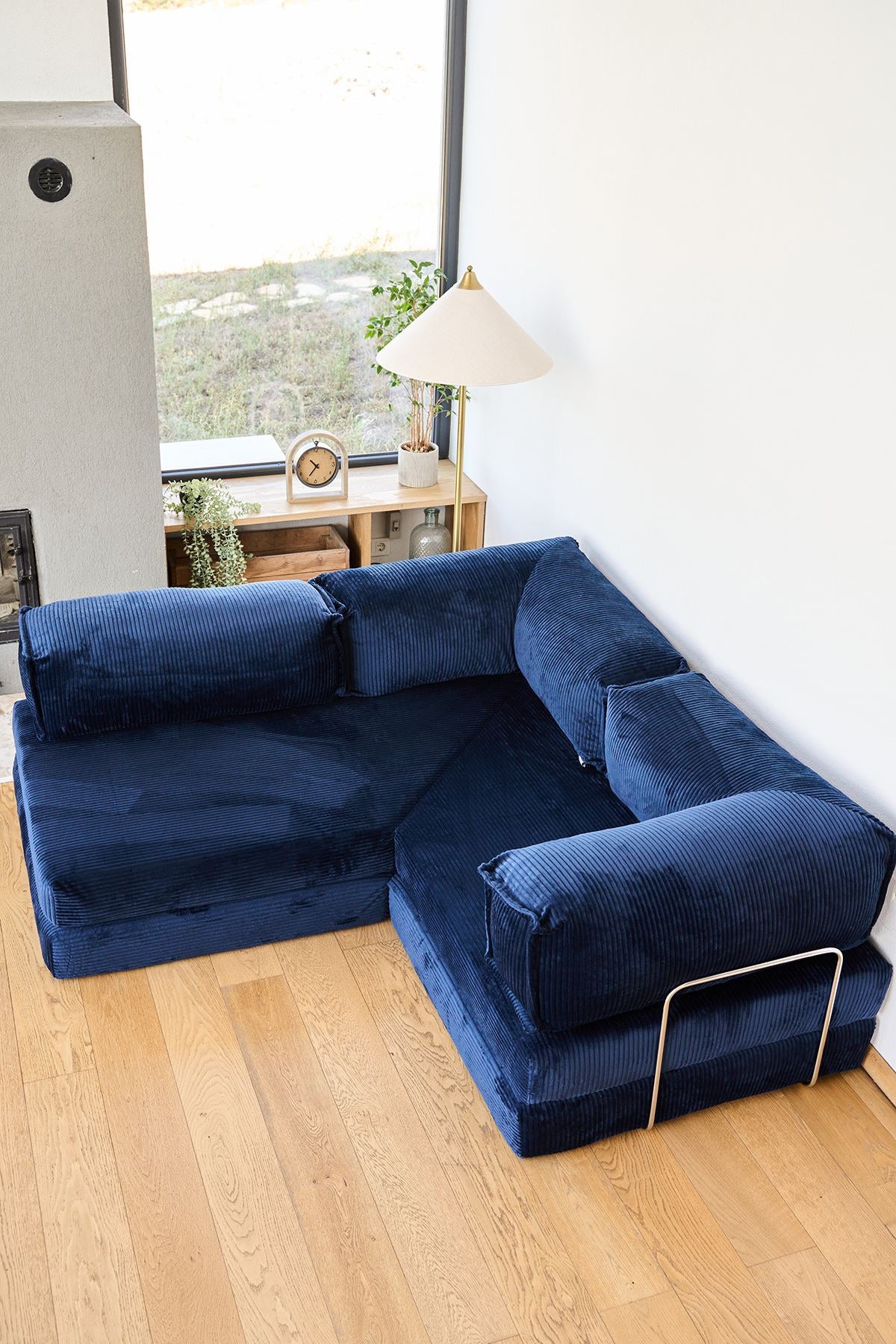 Marineblaues Eck-Schlafsofa aus Cord-Plüschstoff mit vier Kissen, Rollpack-Verpackung und abnehmbarem, waschbarem Bezug.