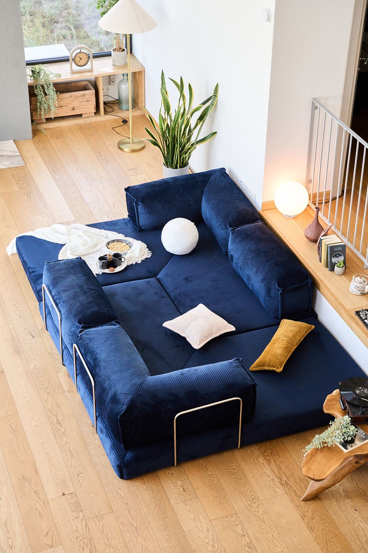 Marineblaues Eck-Schlafsofa aus Cord-Plüschstoff mit vier Kissen, Rollpack-Verpackung und abnehmbarem, waschbarem Bezug.