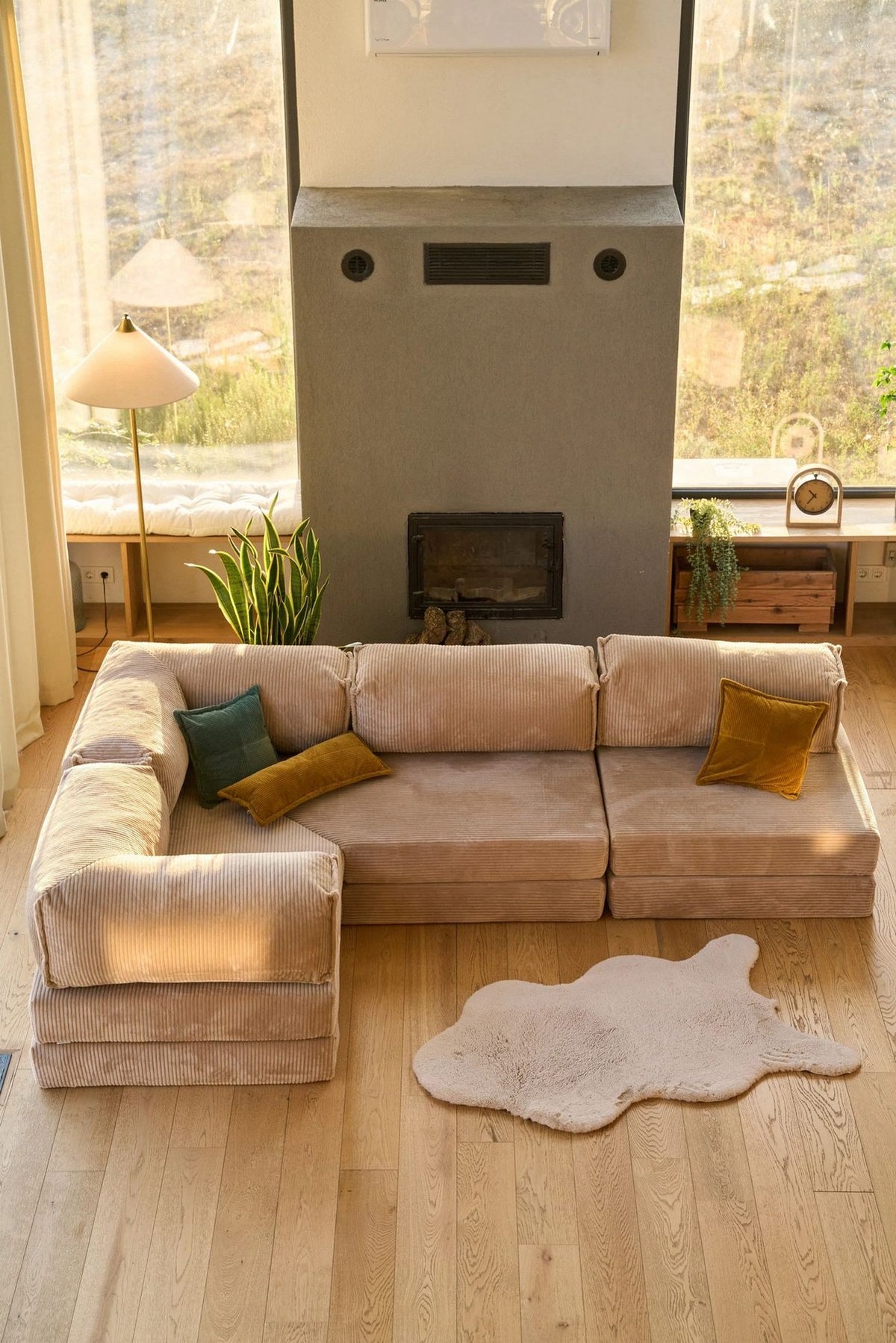 Beiges Eck-Schlafsofa Kanyon von Hanah Home aus geripptem Cord-Plüschstoff, L-Form mit vier Kissen, auf hellem Untergrund fotografiert.