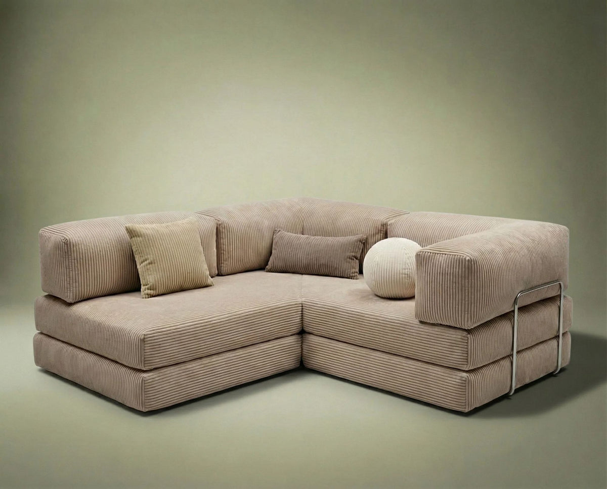 Beiges Eck-Schlafsofa Kanyon von Hanah Home aus geripptem Cord-Plüschstoff, L-Form mit vier Kissen, auf hellem Untergrund fotografiert.